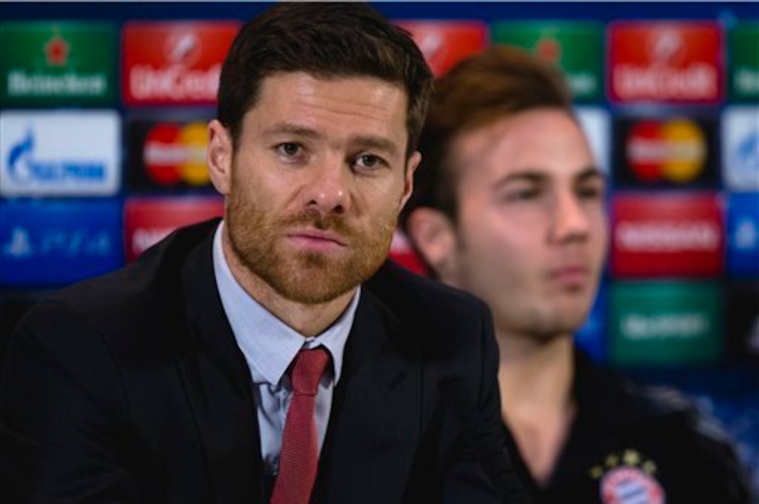 Bayern’s Xabi Alonso, left, sits alongside teammate Mario Goetze during a press conference in Manchester, England, Monday, Nov. 24, 2014. Bayern Munich will play Manchester City on Tuesday in a Champions League Group E soccer match. (AP Photo/Jon Super)
