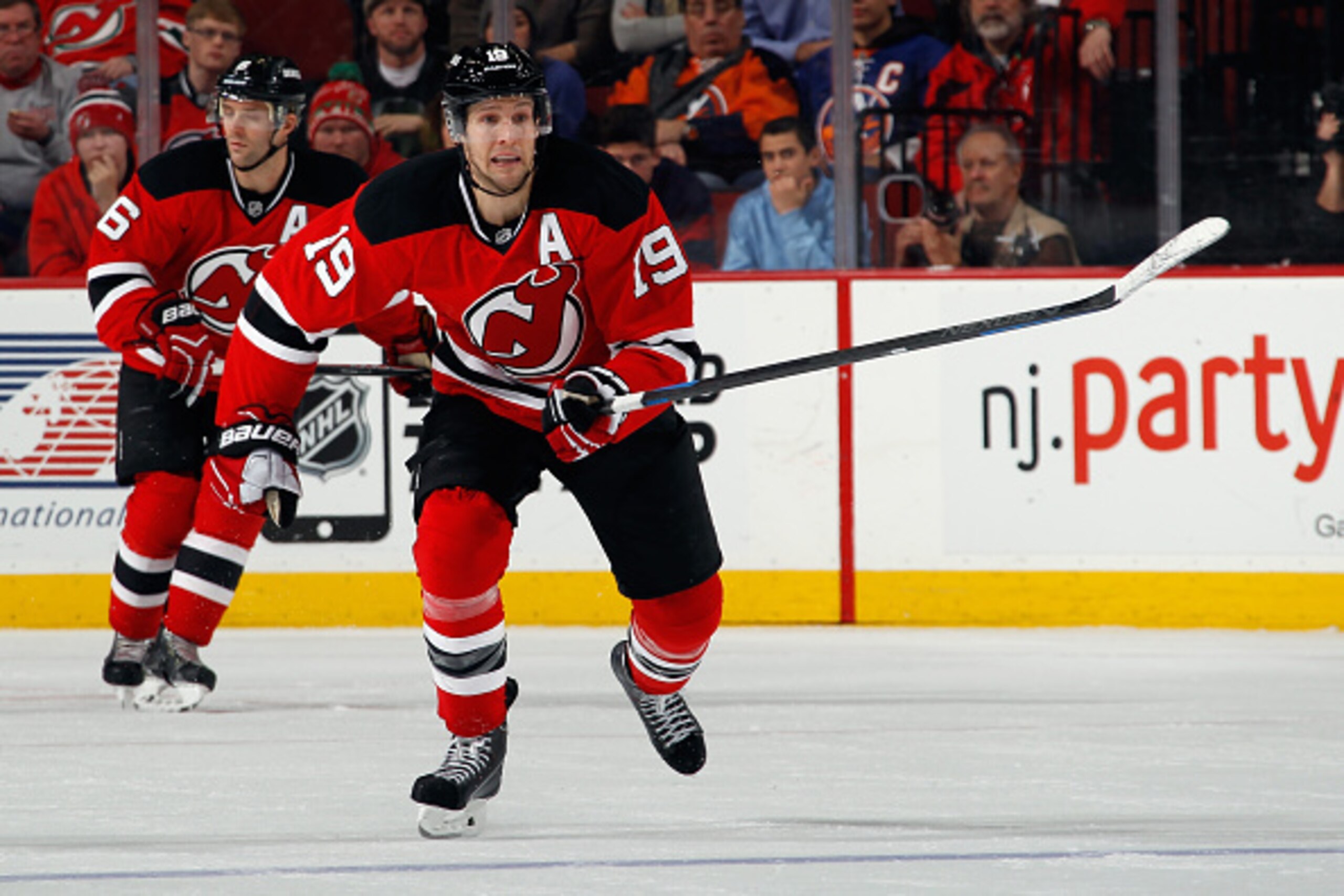 Travis Zajac pursues a puck through the neutral zone.