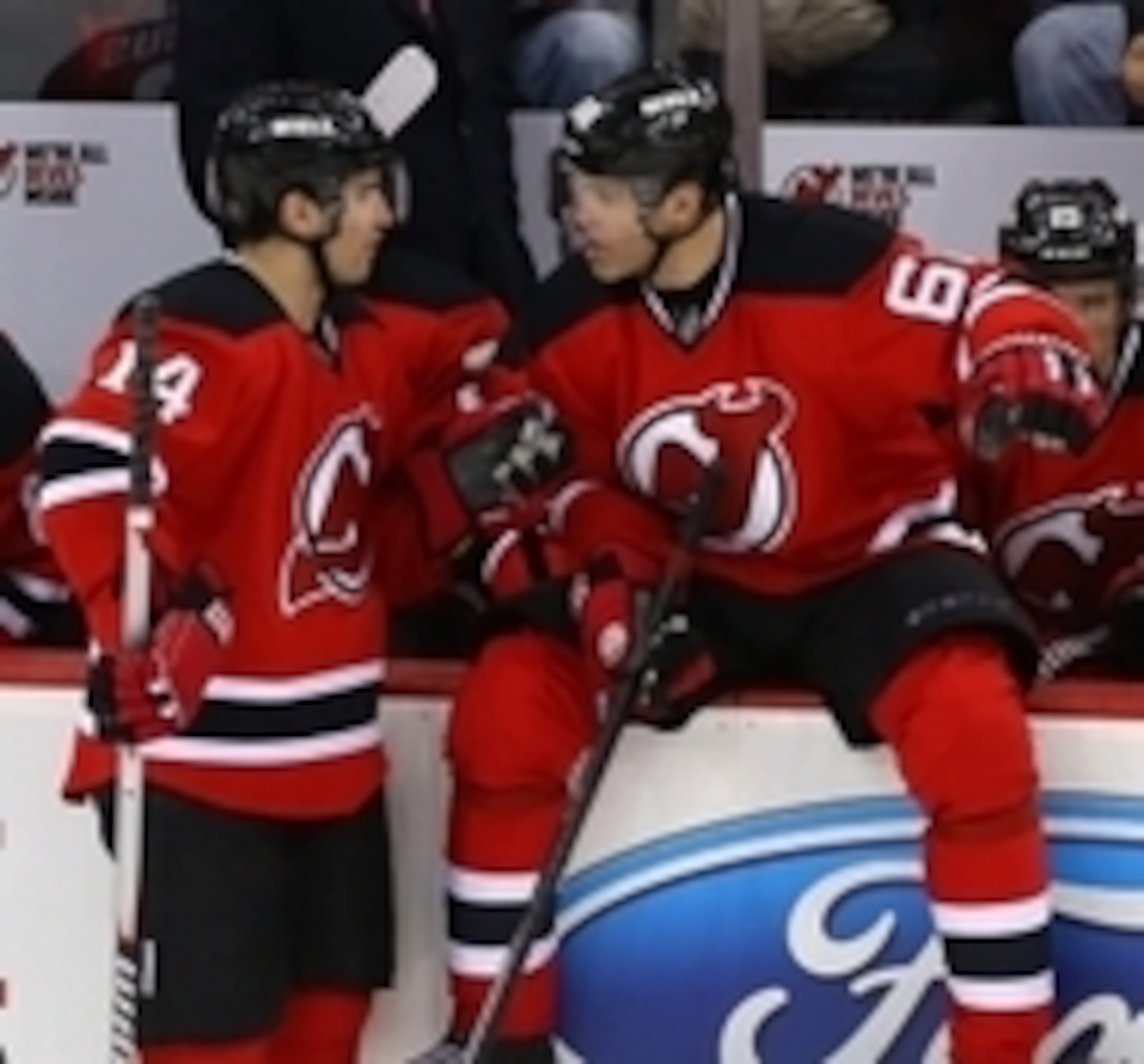 Adam Henrique has a discussion with Jaromir Jagr on the bench.