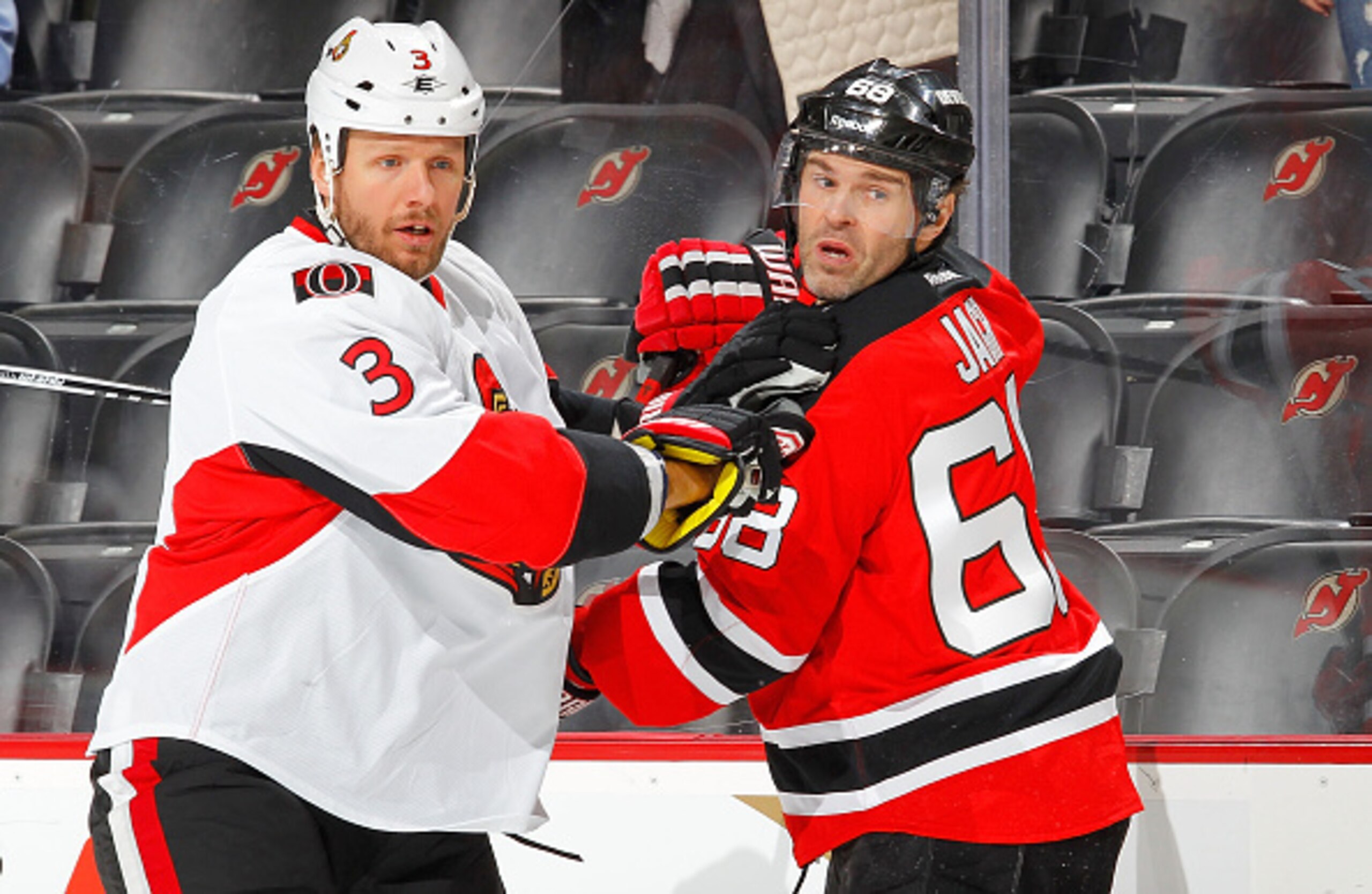 Jaromir Jagr engages with an Ottawa Senator.
