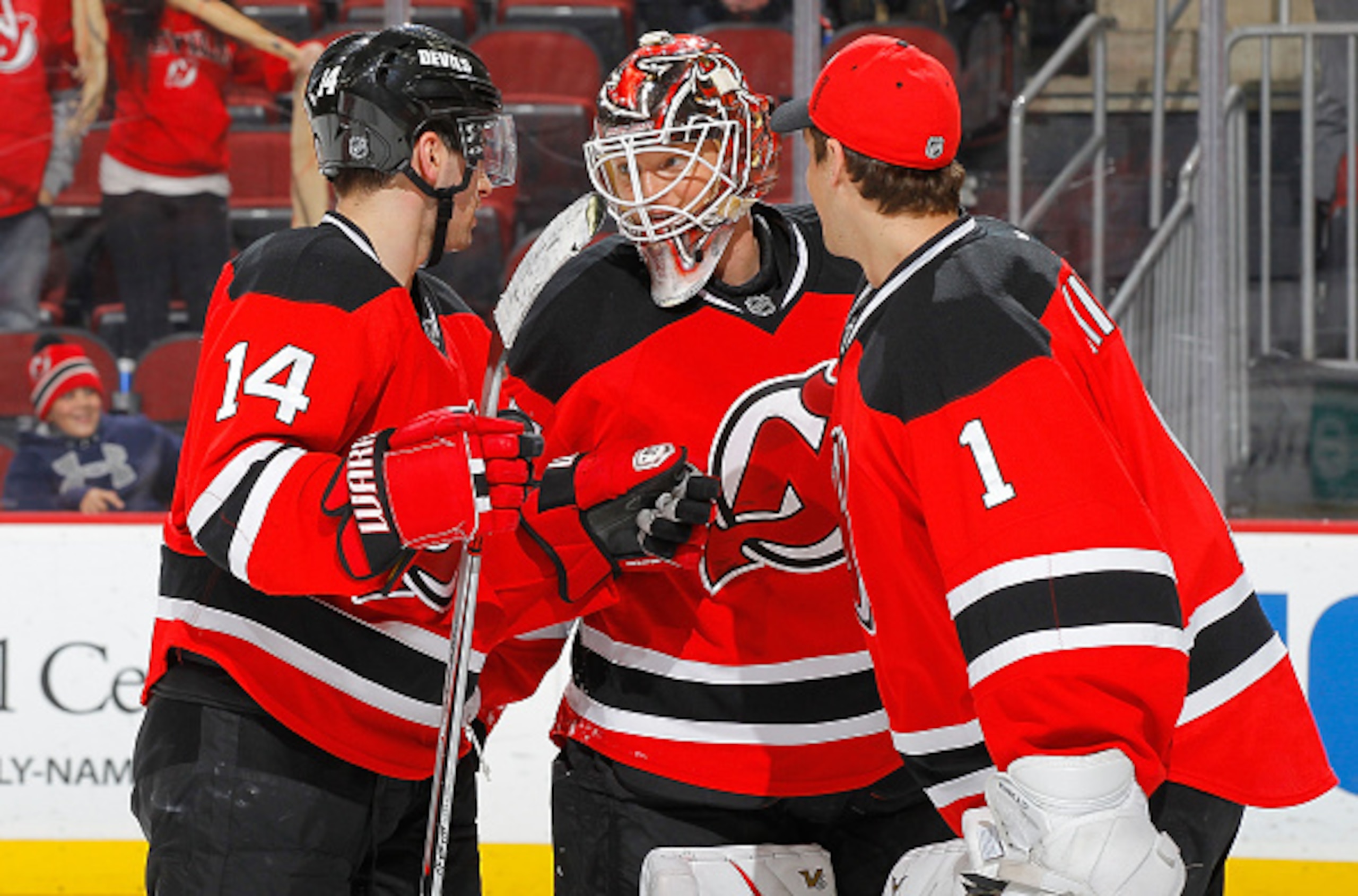 Cory Schneider celebrates a win with teammates Adam Henrique and Keith Kinkaid.