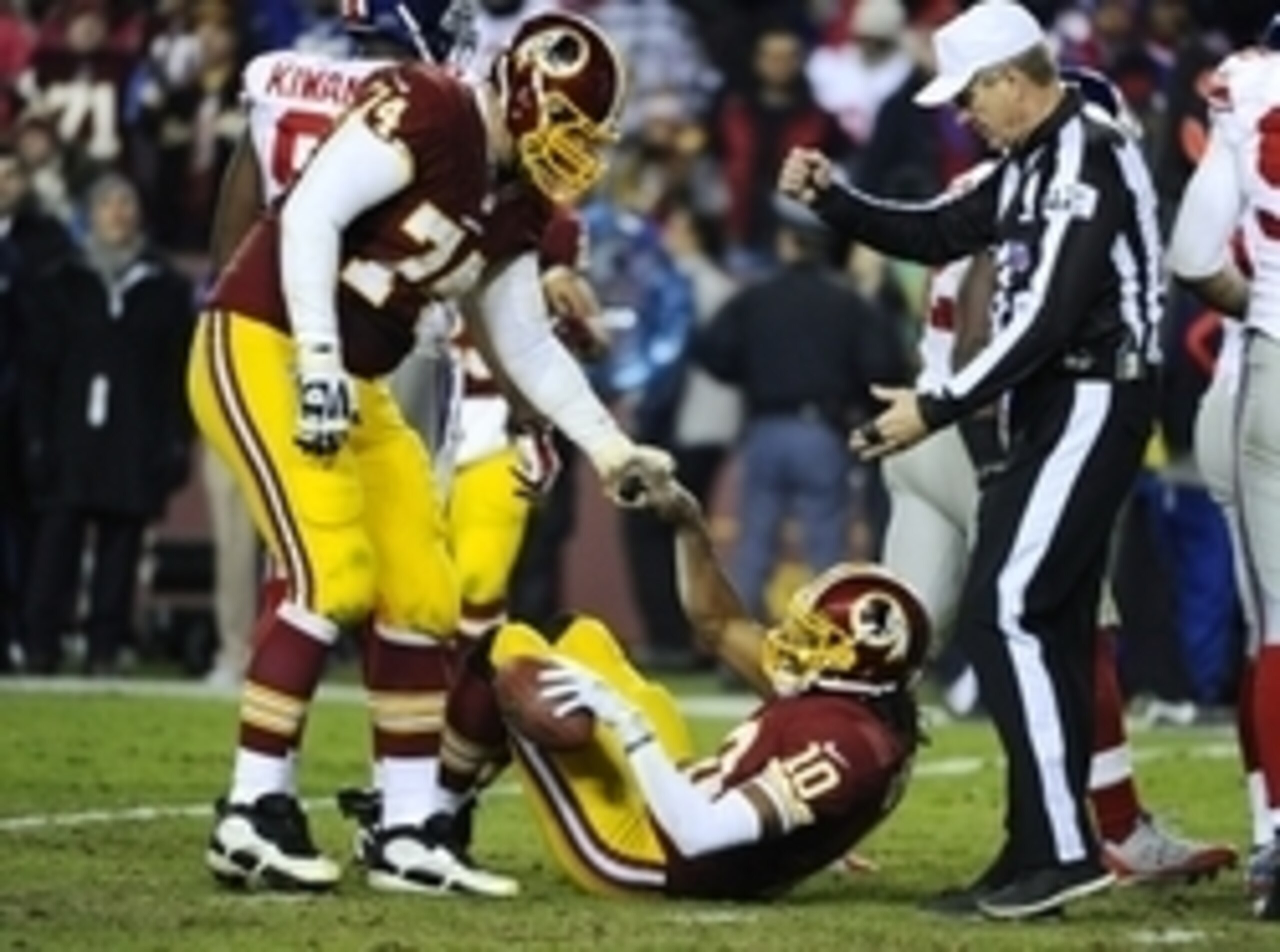 Dec 1, 2013; Landover, MD, USA; Washington Redskins quarterback Robert Griffin III (10) is helped up by offensive tackle Tyler Polumbus (74) after being sacked by the New York Giants during the second half at FedEx Field. The Giants won 24 - 17. Mandatory