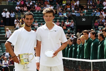 Americans Noah Rubin and Stefan Kozlov pose during the trophy ceremony at the 2014 Wimbledon juniors championship match.