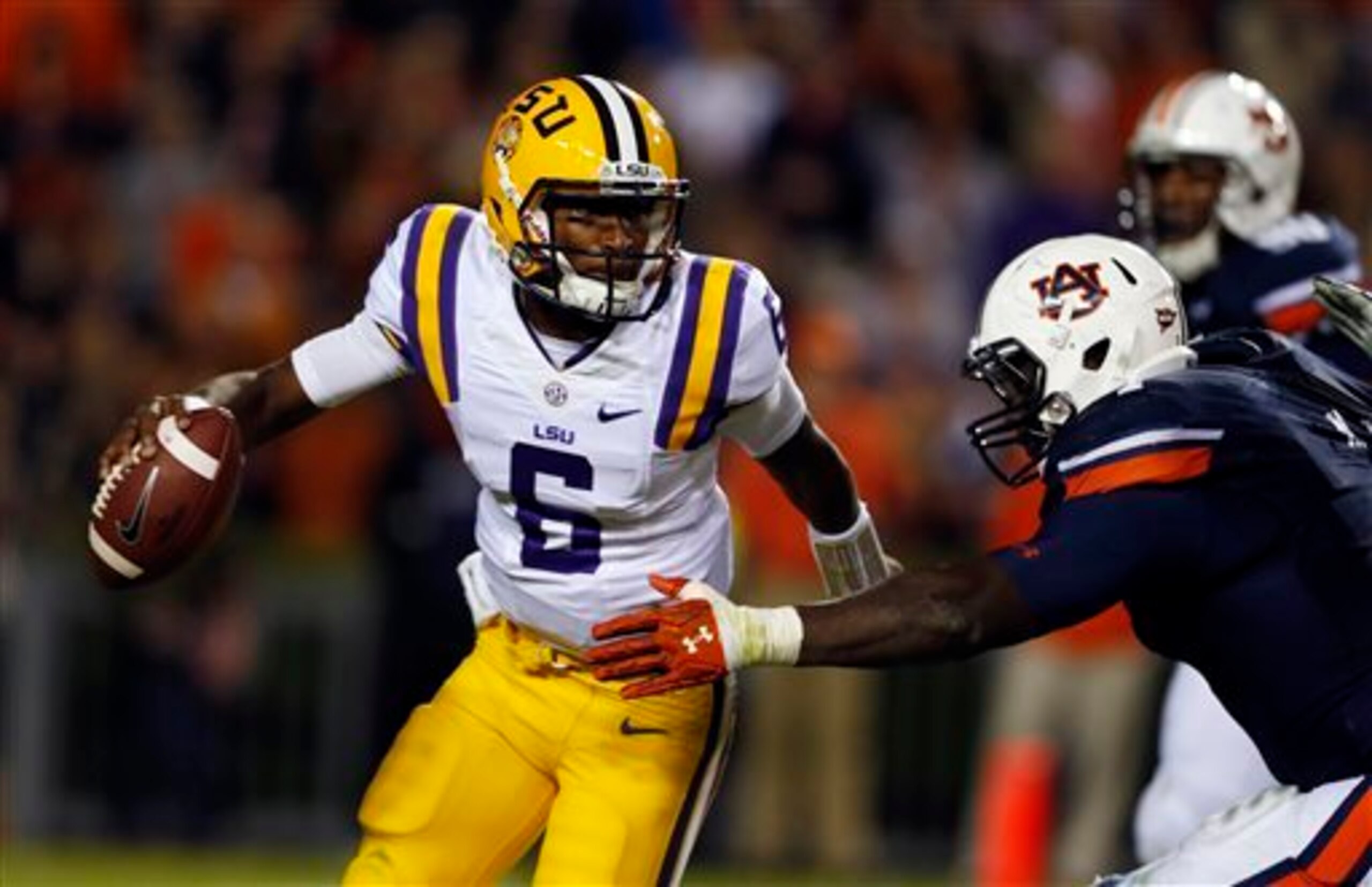 LSU quarterback Brandon Harris attempts to evade the Auburn pass rush.