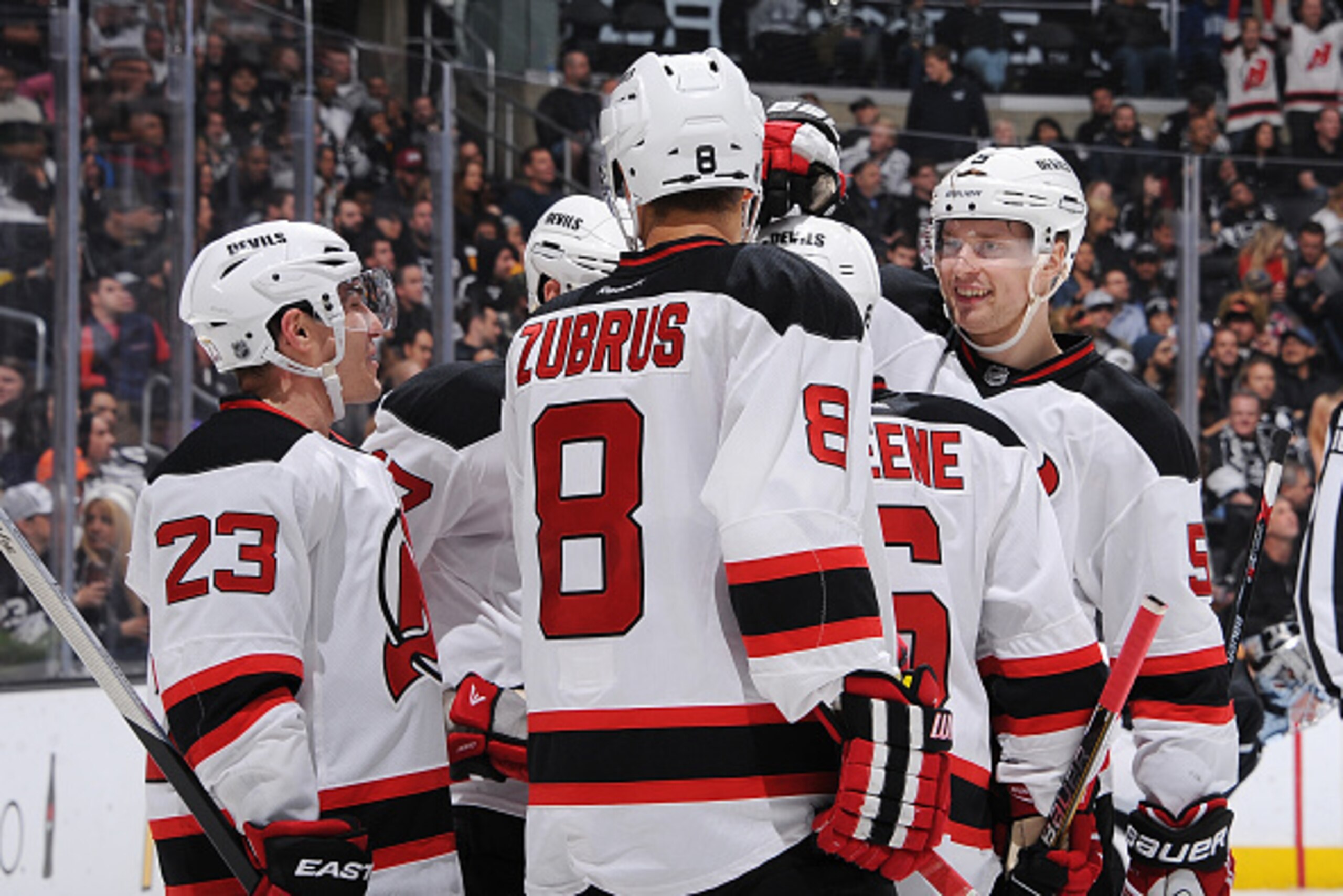 A group of Devils, including Michael Cammalleri, Andy Greene and Adam Larsson celebrate a goal.