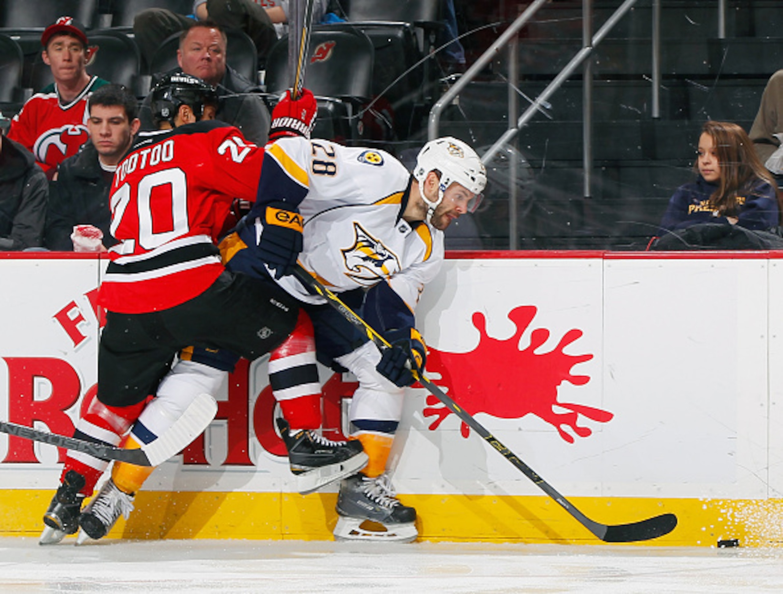 Jordin Tootoo checks a Nashville Predator along the boards.