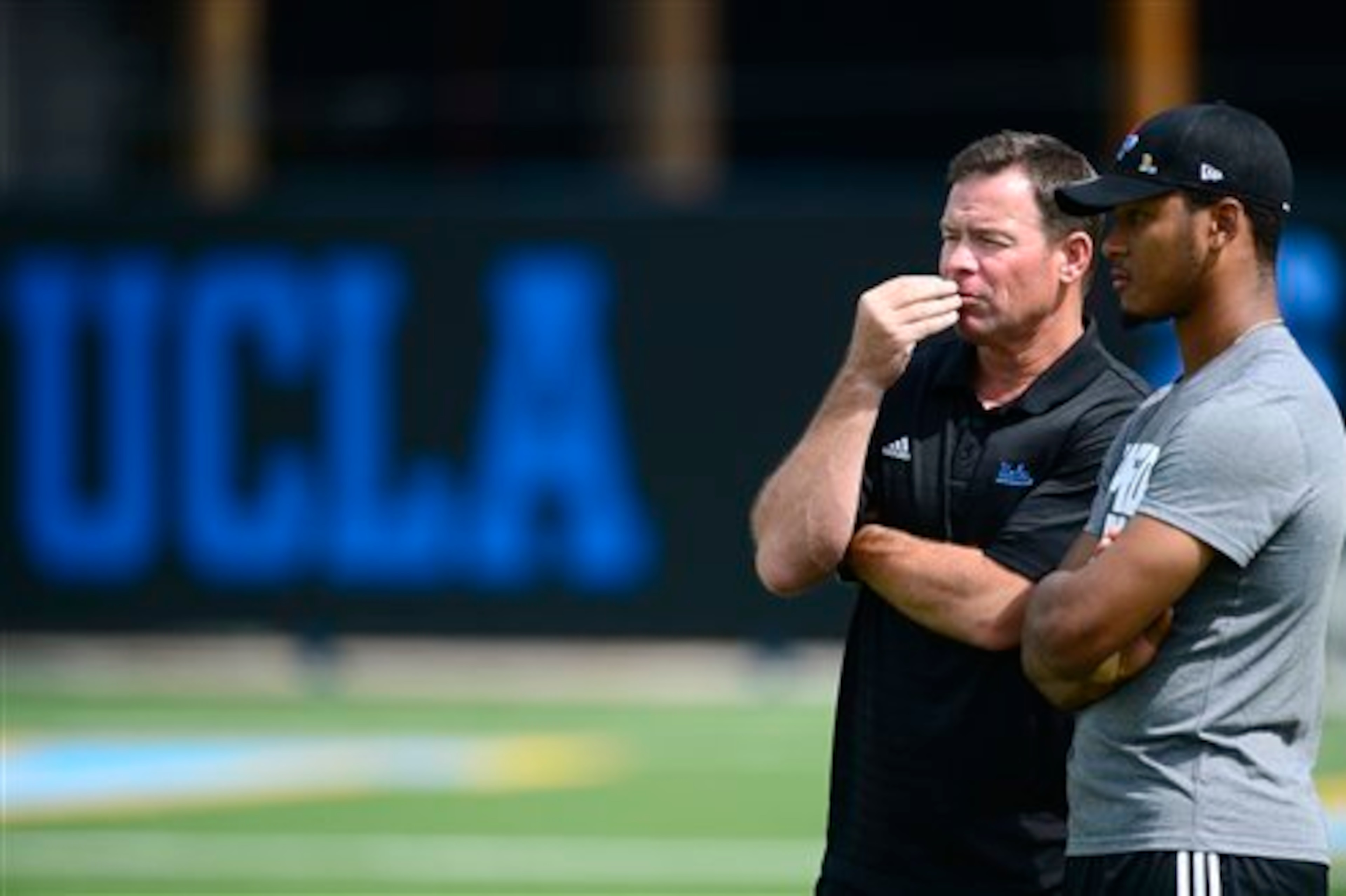 Mora pondering the future with former UCLA QB Brett Hundley.