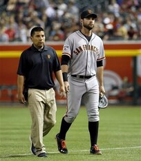 Brandon Belt exits the game with the Giants trainer.
