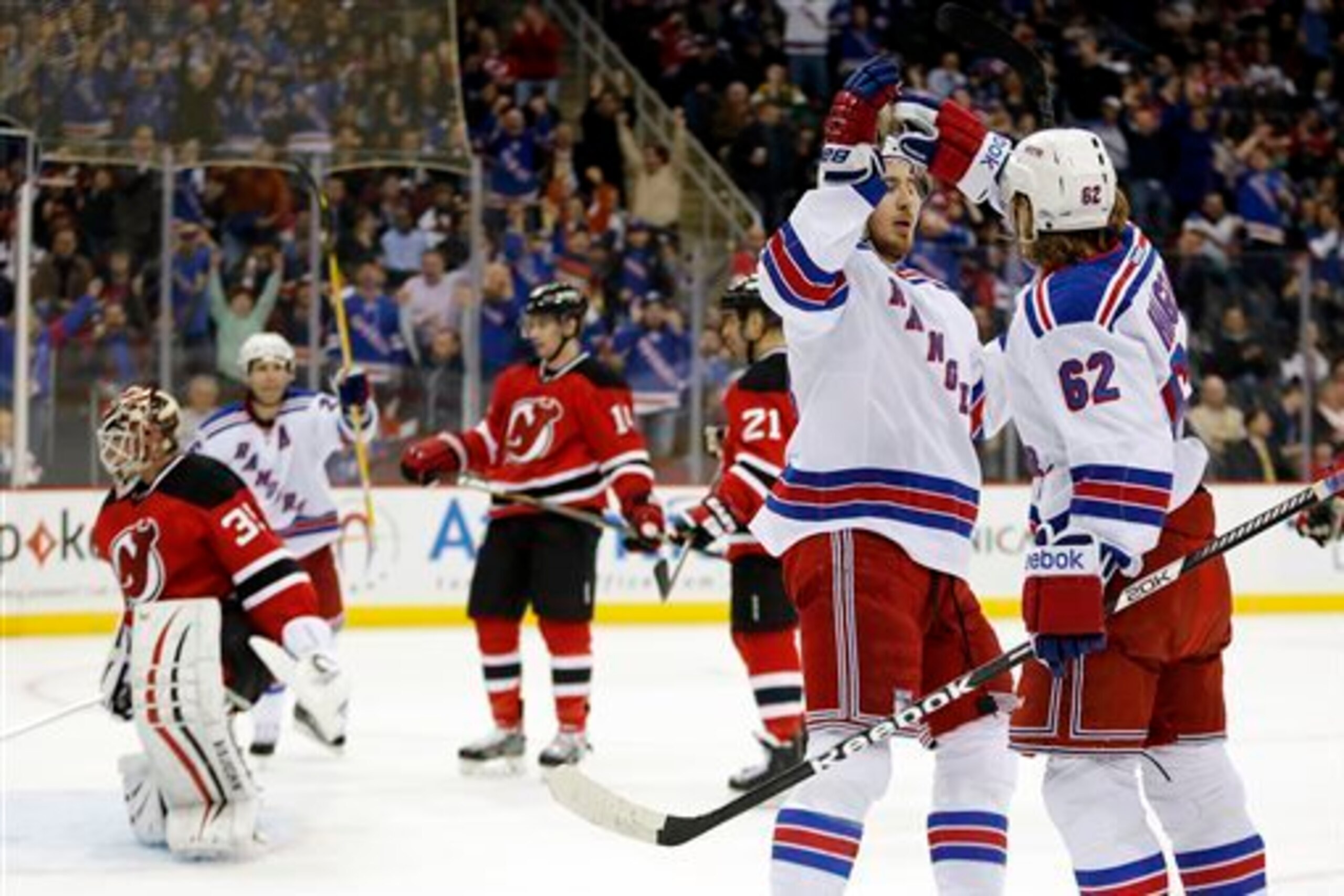 A group of dejected Devils can only look away as the New York Rangers celebrate a goal. A group of dejected Devils can only look away as the New York Rangers celebrate a goal.