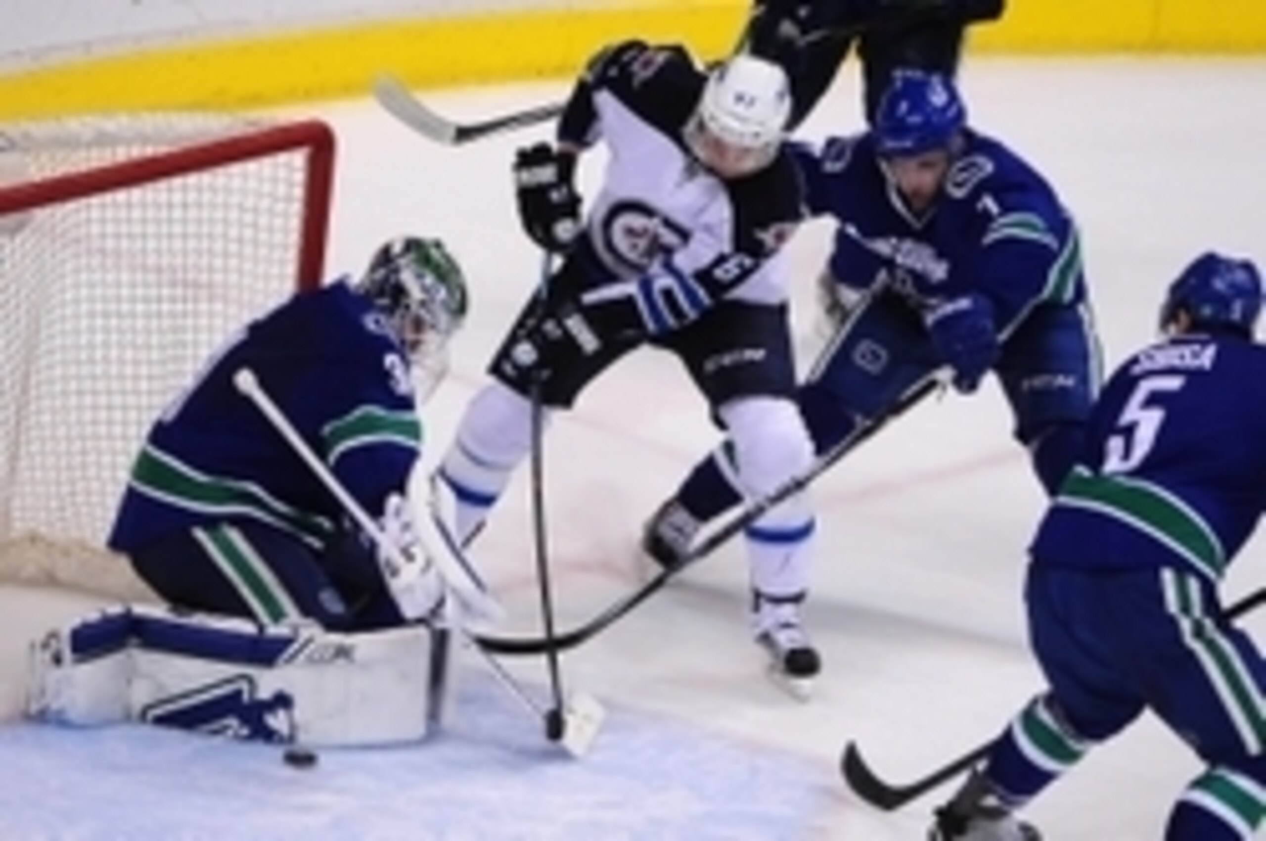 Mar 24, 2015; Vancouver, British Columbia, CAN; Winnipeg Jets forward Michael Frolik (67) skates with the puck as Vancouver Canucks goaltender Eddie Lack (31) and forward Linden Vey (7) defend during the second period at Rogers Arena. Mandatory Credit: An Mar 24, 2015; Vancouver, British Columbia, CAN; Winnipeg Jets forward Michael Frolik (67) skates with the puck as Vancouver Canucks goaltender Eddie Lack (31) and forward Linden Vey (7) defend during the second period at Rogers Arena. Mandatory Credit: An