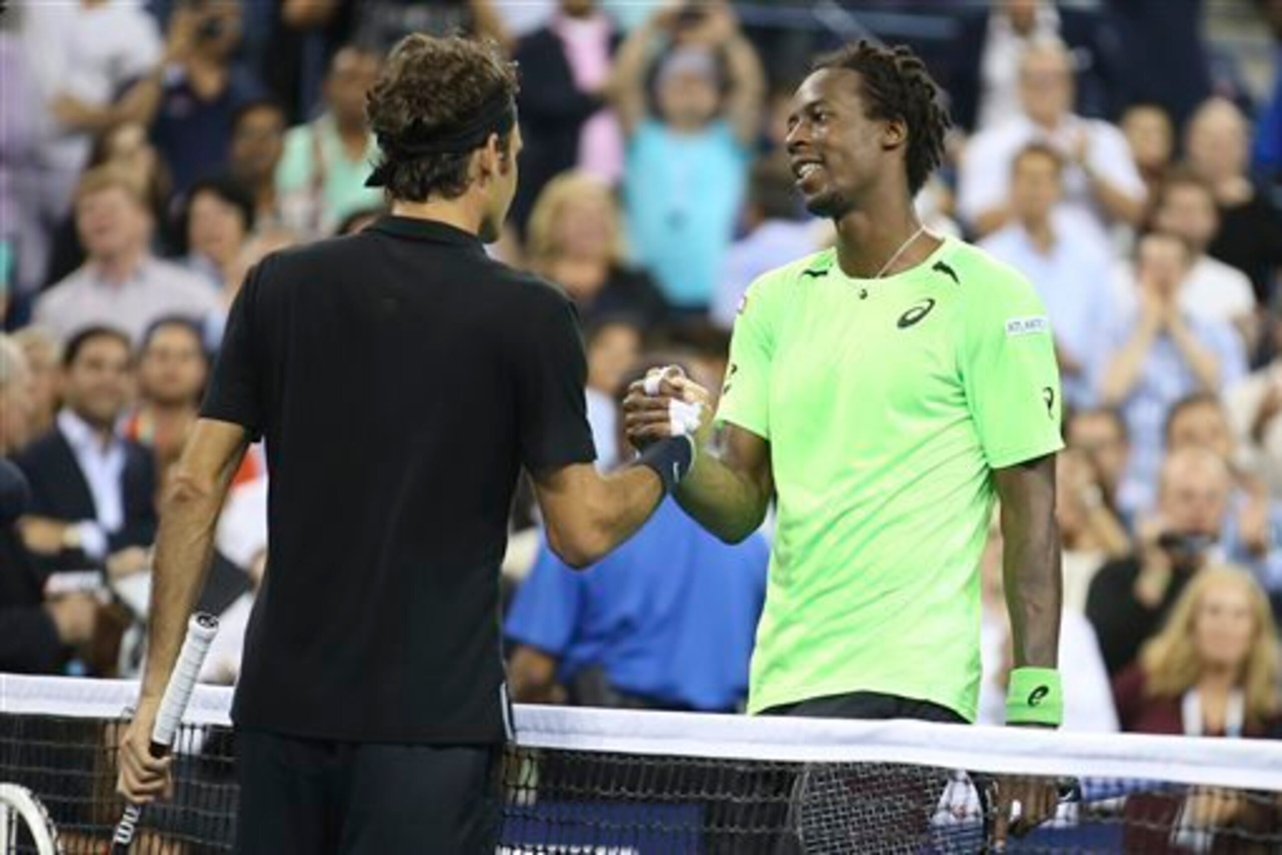 Roger Federer greets Gael Monfils at the net after their match during the 2014 U.S. Open.