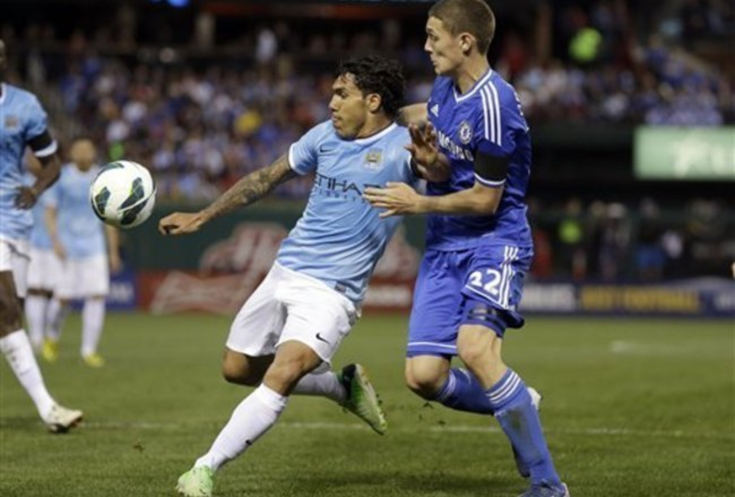 Christensen (right) challenges Carlos Tevez in 2013
