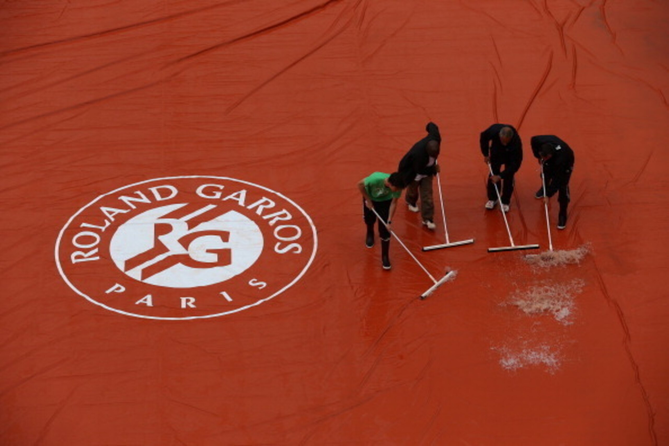The grounds crew works on a rain-soaked court at Roland Garros during the 2014 French Open.