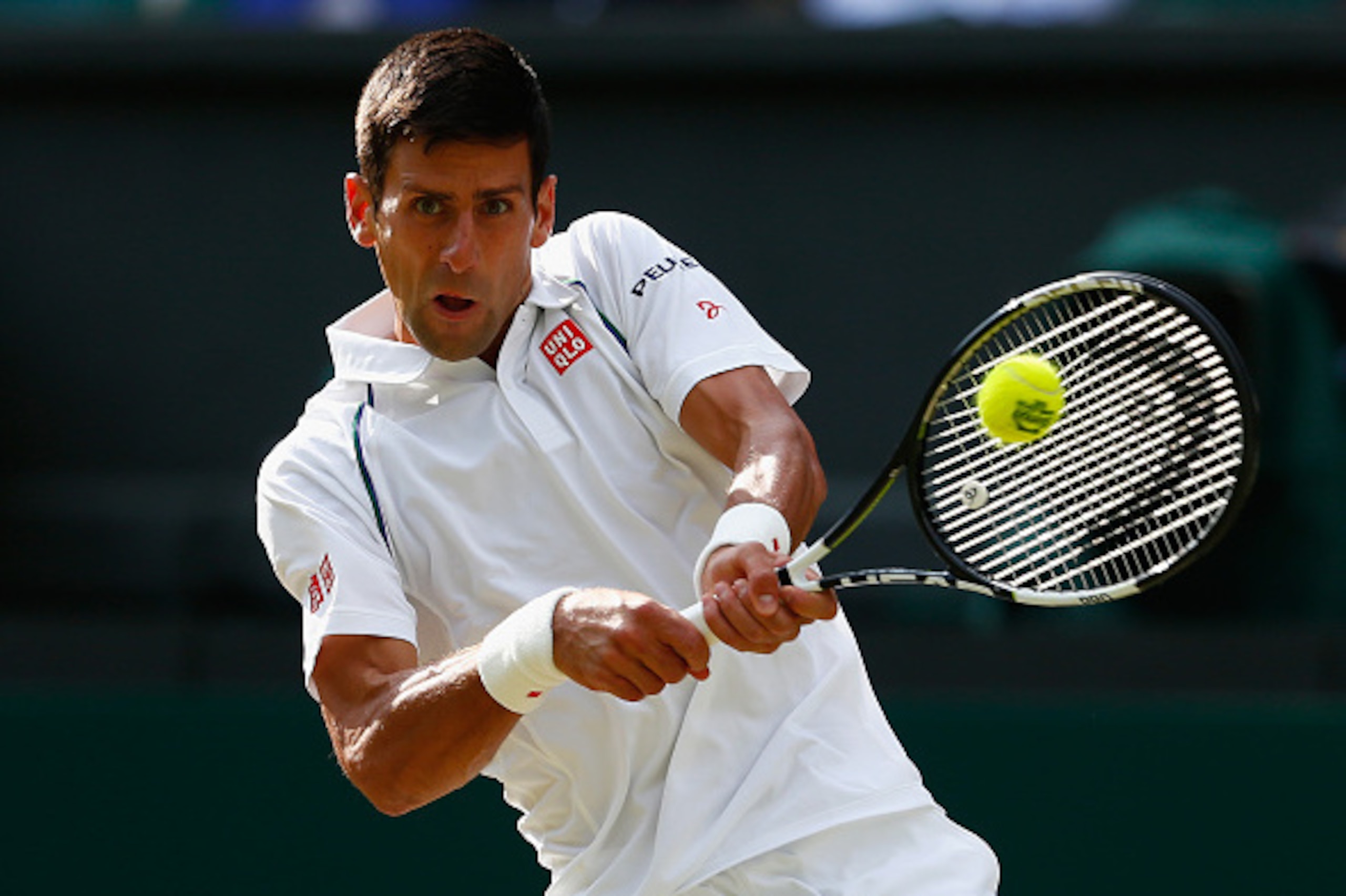 Novak Djokovic hits a backhand during a quarterfinals match at Wimbledon.