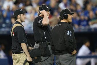 MLB umpires consult to review a call on the field.