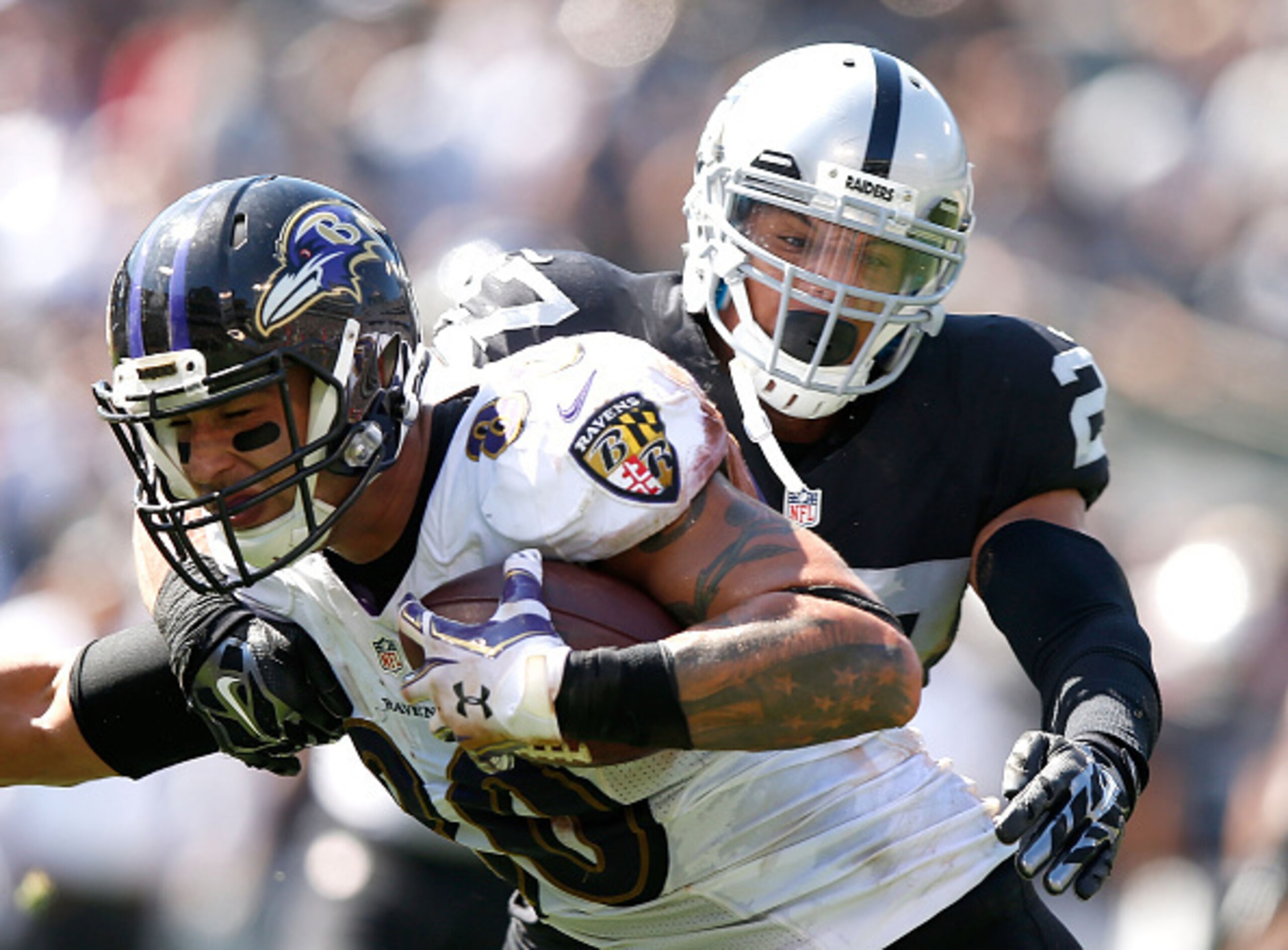 Raiders safety Taylor Mays attempts to tackle Ravens tight end Crockett Gillmore.