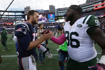 Tom Brady and Muhammad Wilkerson meet after the Patriots victory over the Jets.