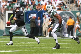 Calvin Pace chases down Derek Carr during the 2014 NFL season opener for both teams.