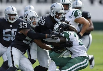 Chris Ivory is brought down by a host of Oakland Raiders.