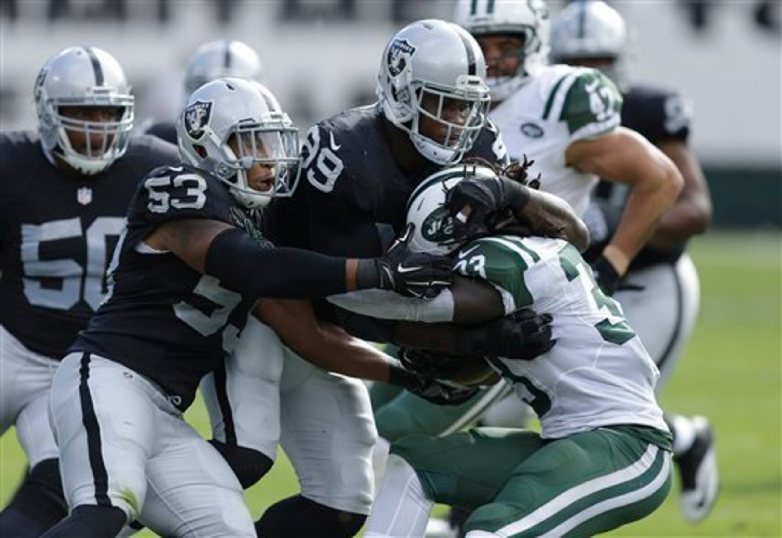Chris Ivory is brought down by a host of Oakland Raiders.