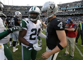 Darrelle Revis talks to Raiders quarterback Derek Carr.