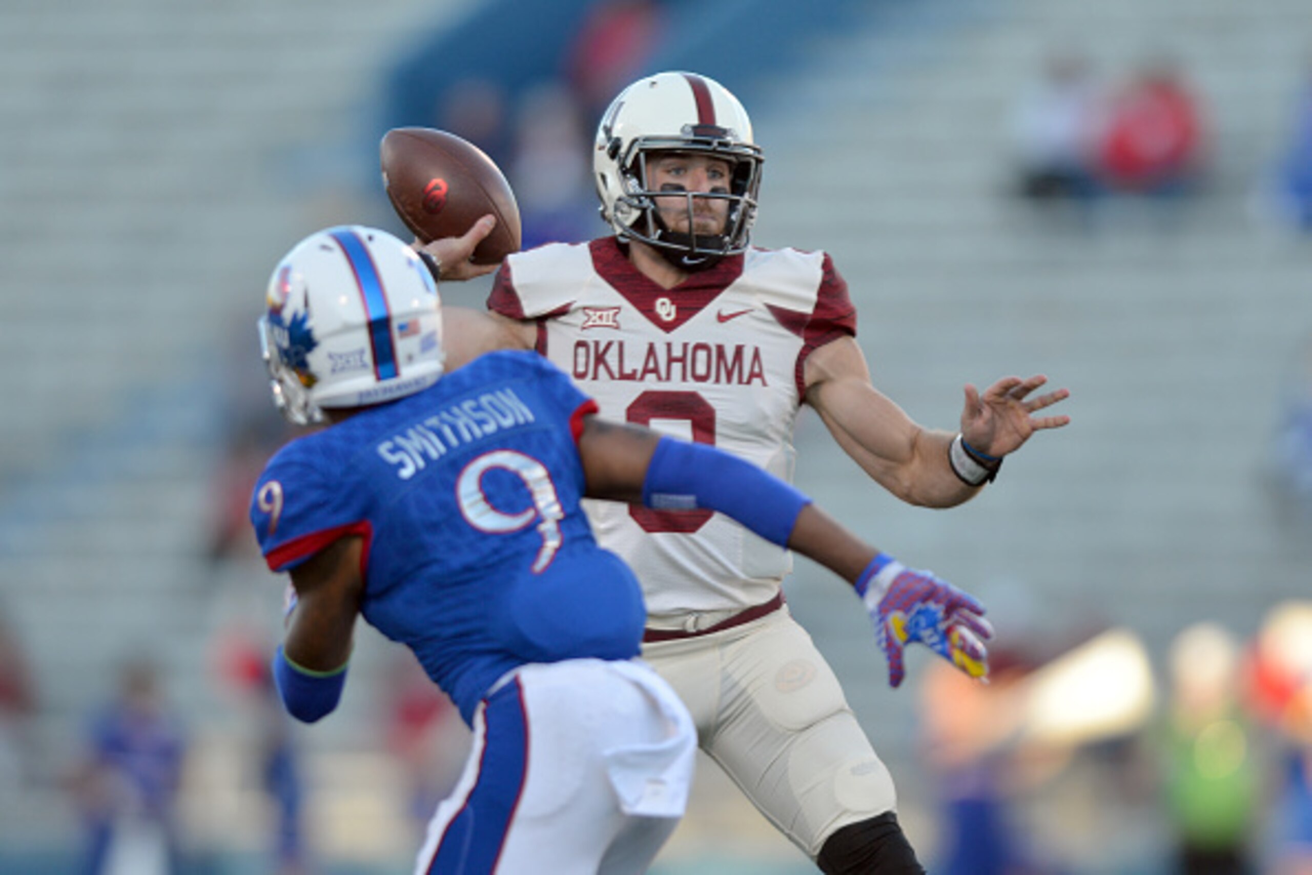 LAWRENCE, KS - OCTOBER 31: Quarterback Trevor Knight #9 of the Oklahoma Sooners attempts a second half pass against pressure from safety Fish Smithson #9 of the Kansas Jayhawks during the Sooners victory on October 31, 2015 at Kansas Memorial Stadium in LAWRENCE, KS - OCTOBER 31: Quarterback Trevor Knight #9 of the Oklahoma Sooners attempts a second half pass against pressure from safety Fish Smithson #9 of the Kansas Jayhawks during the Sooners victory on October 31, 2015 at Kansas Memorial Stadium in
