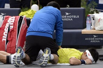 Kei Nishikori receives medical attention before retiring from his match at the Paris Indoors.