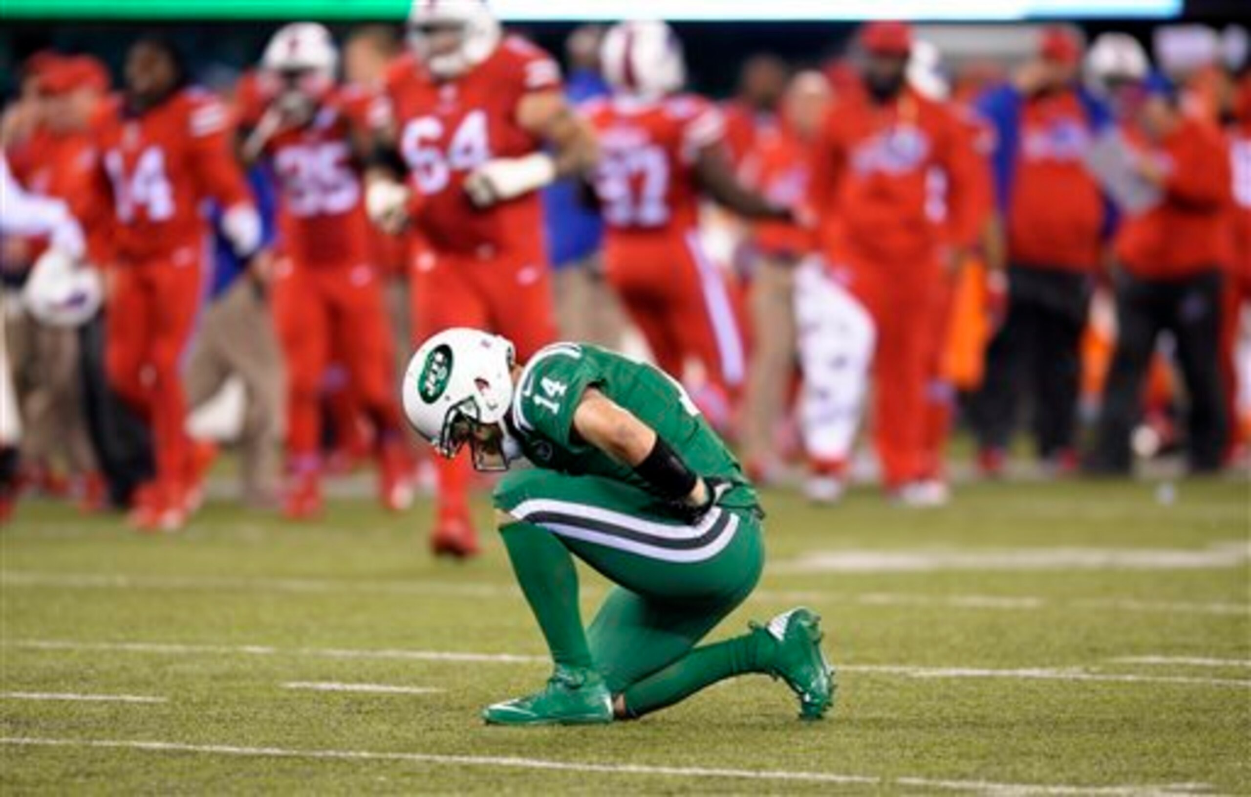 Ryan Fitzpatrick kneels on the field.