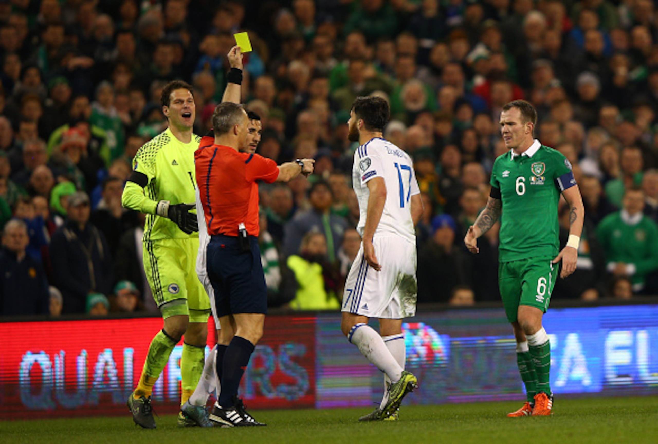 DUBLIN, IRELAND - NOVEMBER 16:  Emilijus Zubas of Bosnia and Herzegovina is shown the yellow card by referee Bjorn Kuipers of Netherlands during the UEFA EURO 2016 Qualifier play off, second leg match between Republic of Ireland and Bosnia and Herzegovina