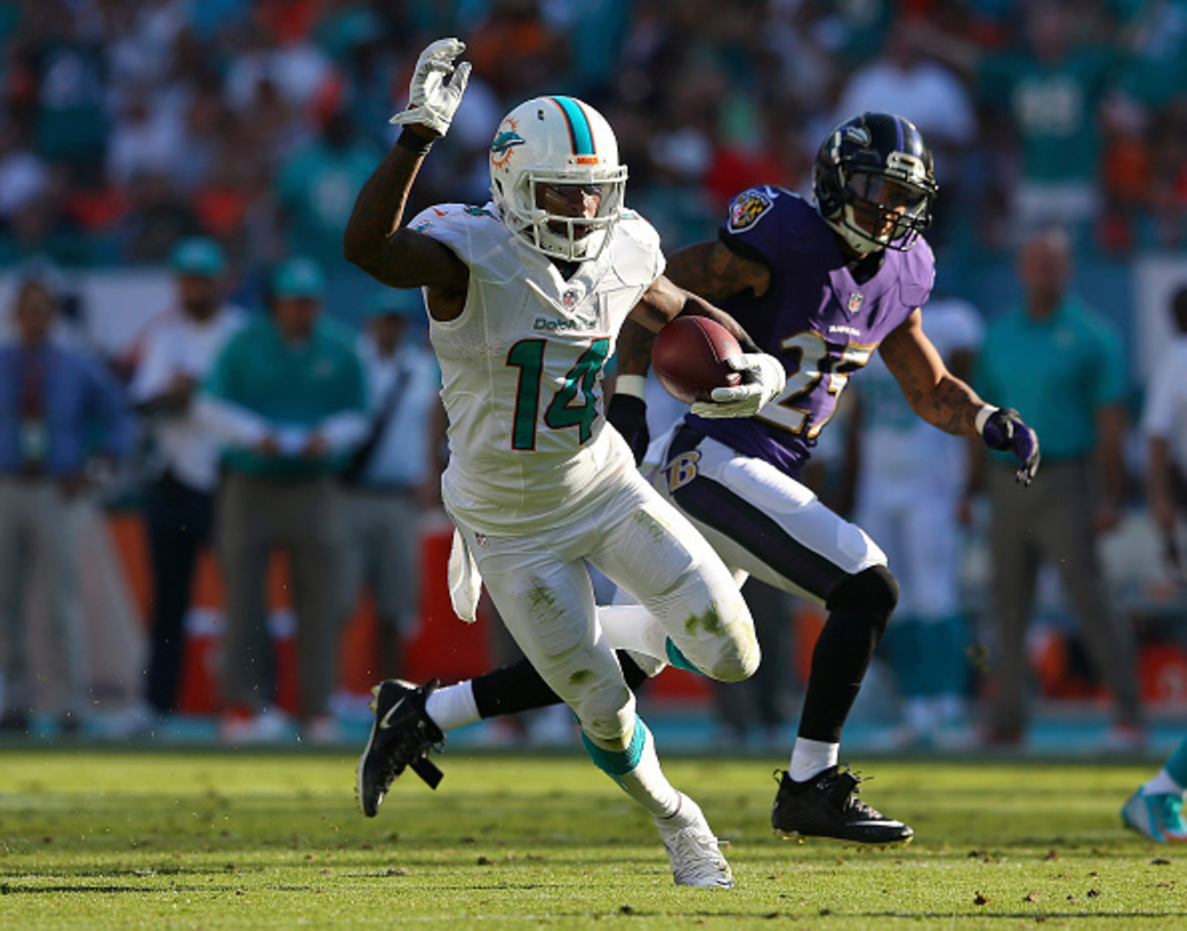 MIAMI GARDENS, FL - DECEMBER 07:  Wide receiver Jarvis Landry #14 of the Miami Dolphins picks up second-half yardage as cornerback Asa Jackson #25 of the Baltimore Ravens pursues during a game at Sun Life Stadium on December 7, 2014 in Miami Gardens, Flor