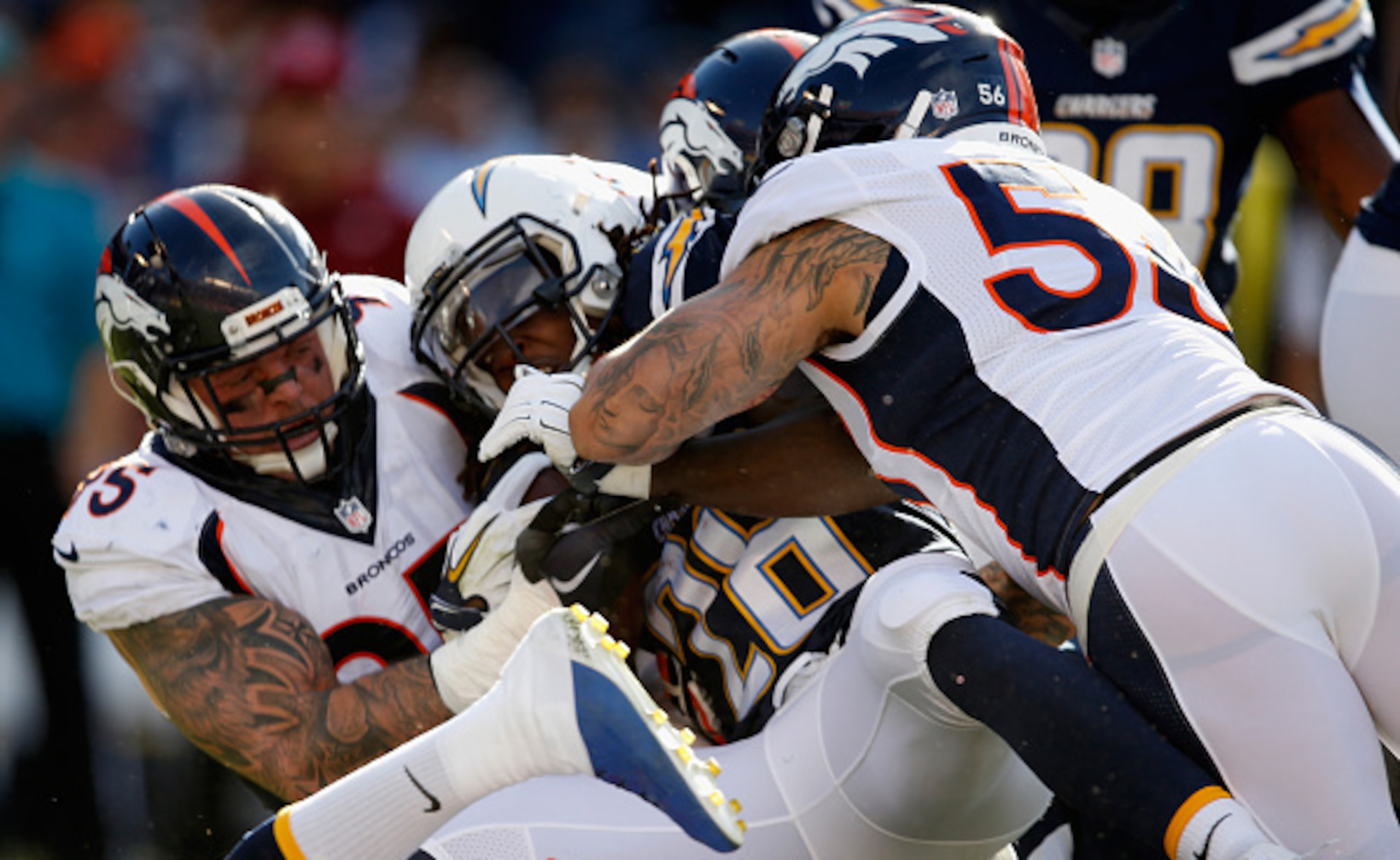 SAN DIEGO, CA - DECEMBER 06:   Derek Wolfe #95 of the Denver Broncos and  Shane Ray #56 of the Denver Broncos tackle  Melvin Gordon #28 of the San Diego Chargers during the first quarter of a game at Qualcomm Stadium on December 6, 2015 in San Diego, Cali