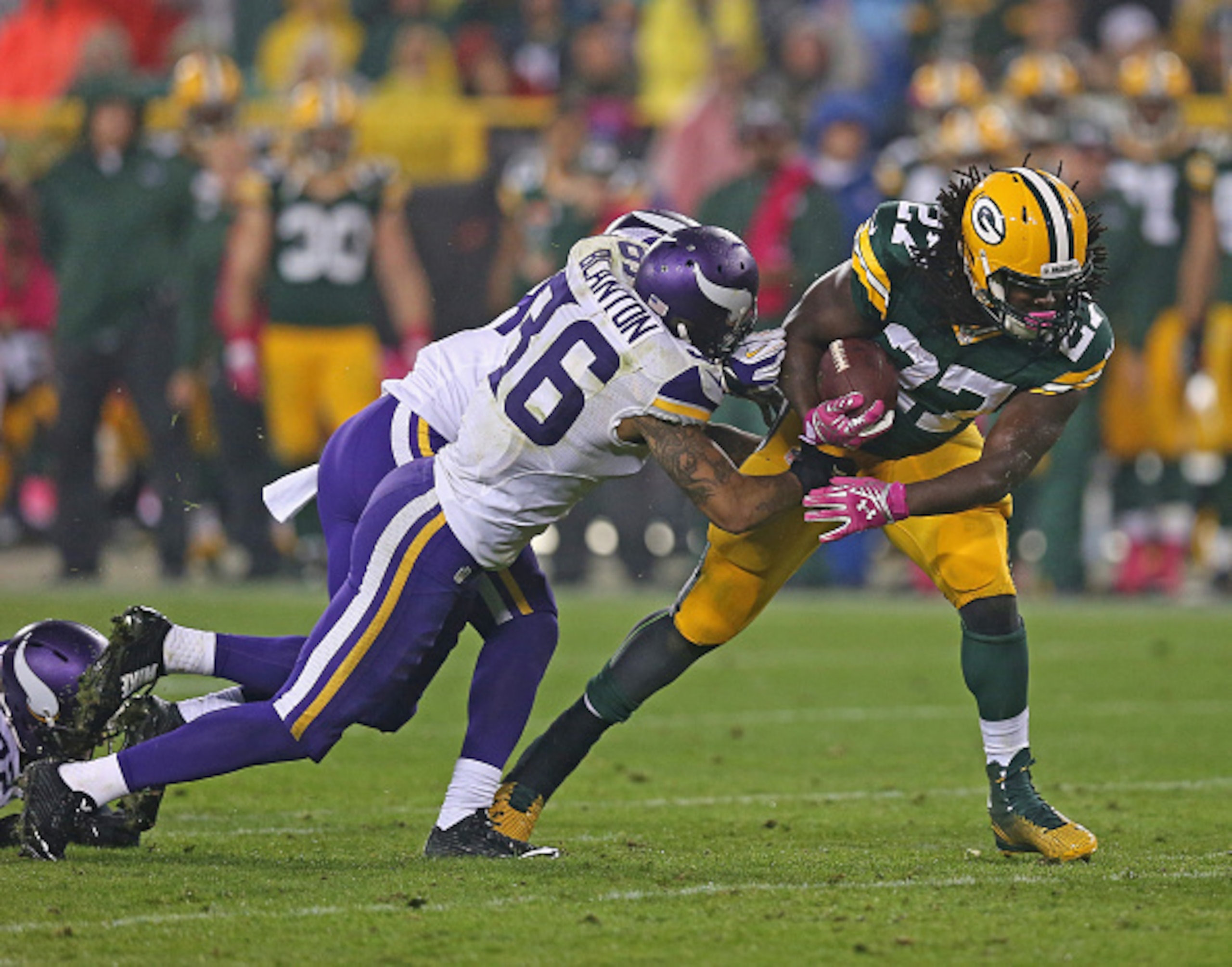 GREEN BAY, WI - OCTOBER 02:  Eddie Lacy #27 of the Green Bay Packers carries the football for a first down against  Robert Blanton #36 and Captain Munnerlyn #24 of the Minnesota Vikings in the third quarter at Lambeau Field on October 2, 2014 in Green Bay