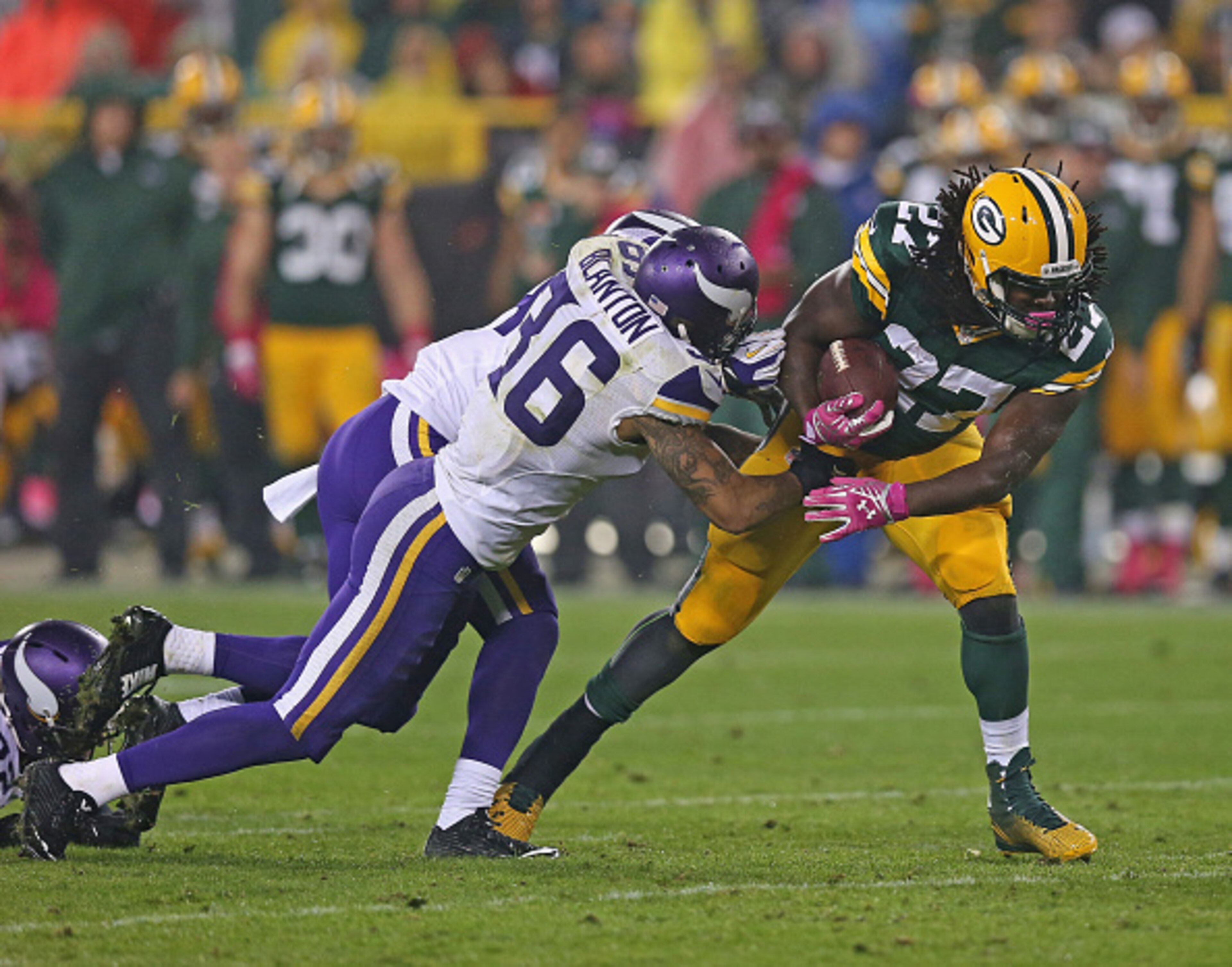 GREEN BAY, WI - OCTOBER 02:  Eddie Lacy #27 of the Green Bay Packers carries the football for a first down against  Robert Blanton #36 and Captain Munnerlyn #24 of the Minnesota Vikings in the third quarter at Lambeau Field on October 2, 2014 in Green Bay