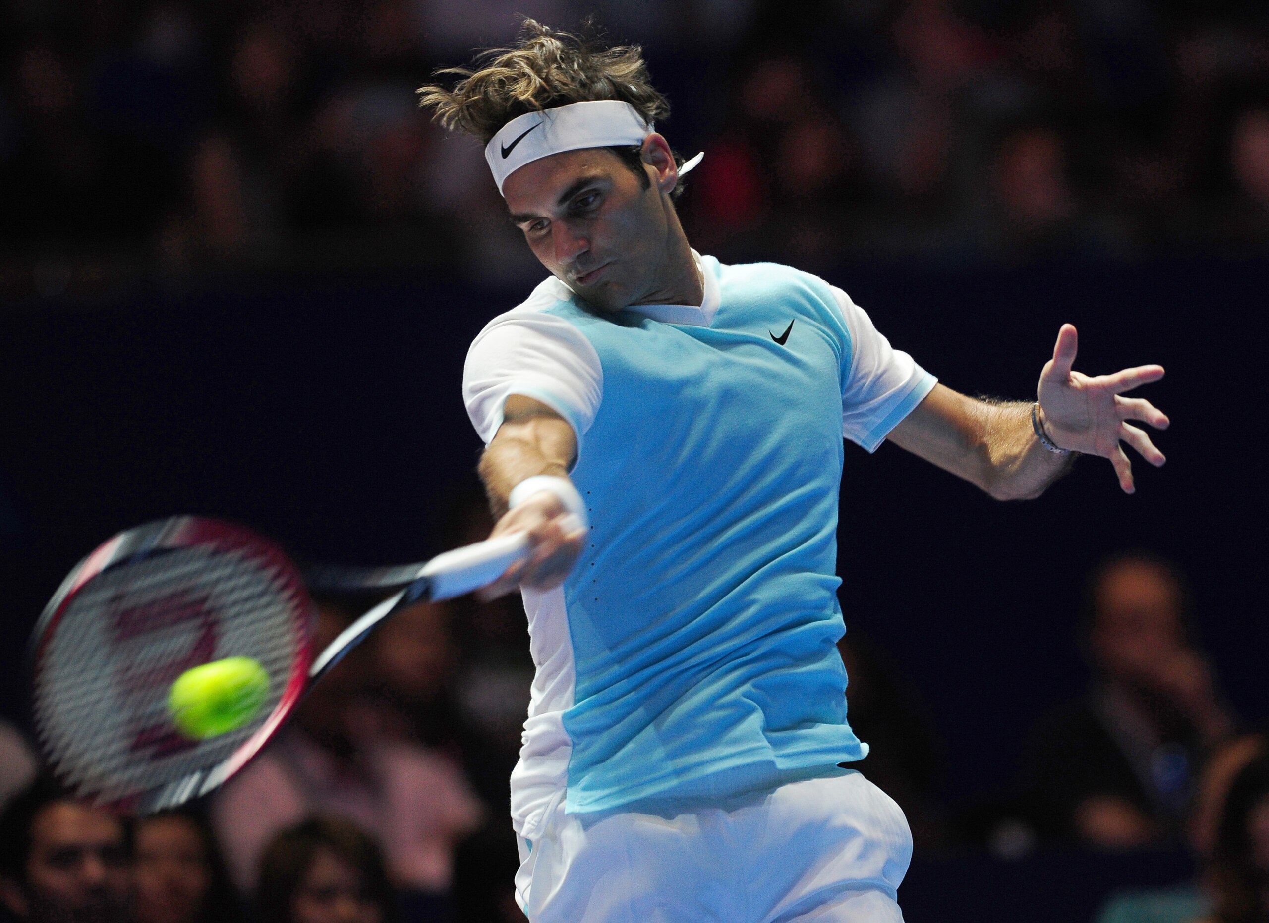Roger Federer glides into a forehand during a 2015 IPTL match.