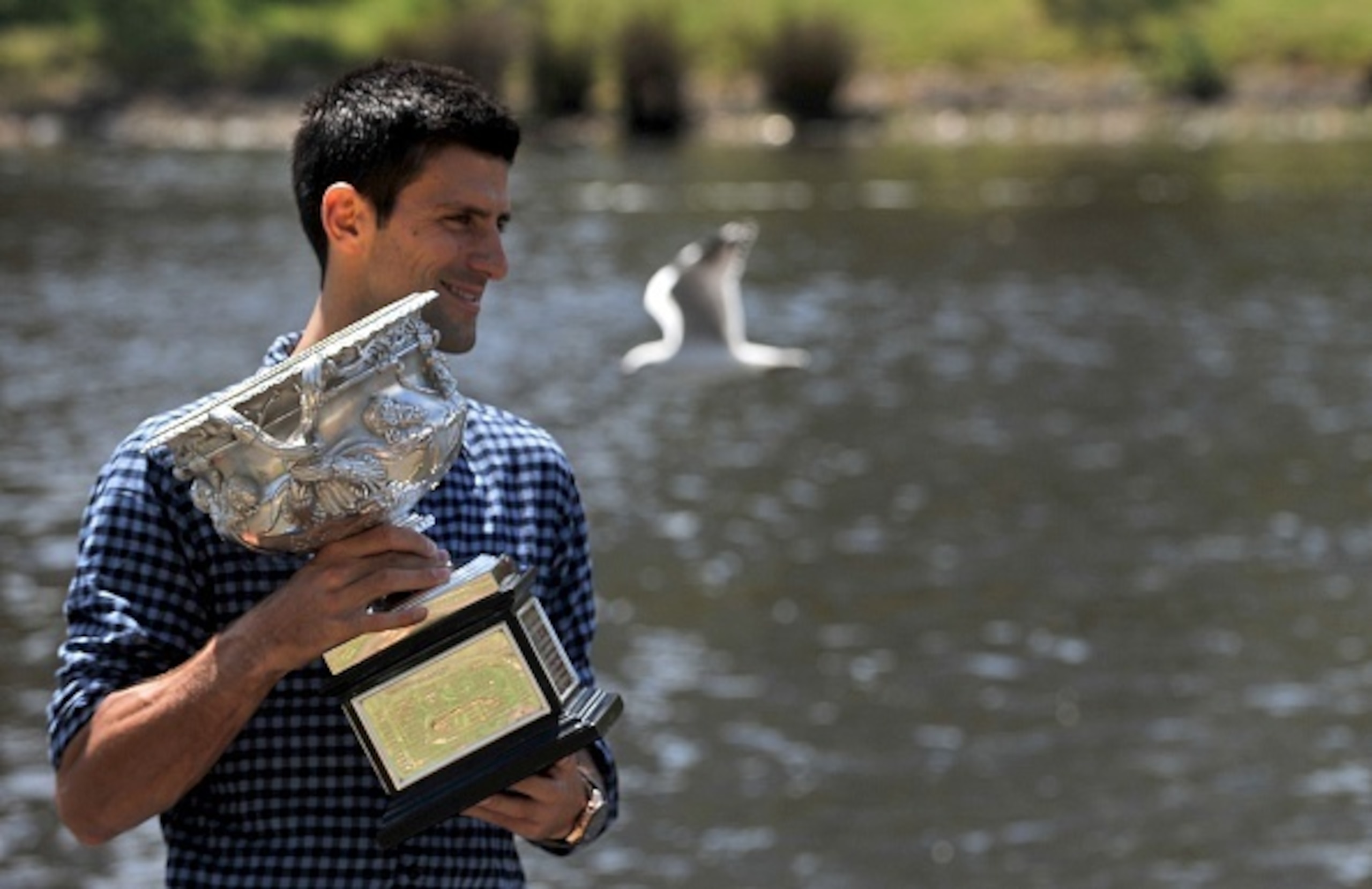 Novak Djokovic poses with the 2015 Australian Open trophy along the Yarra River in downtown Melbourne.
