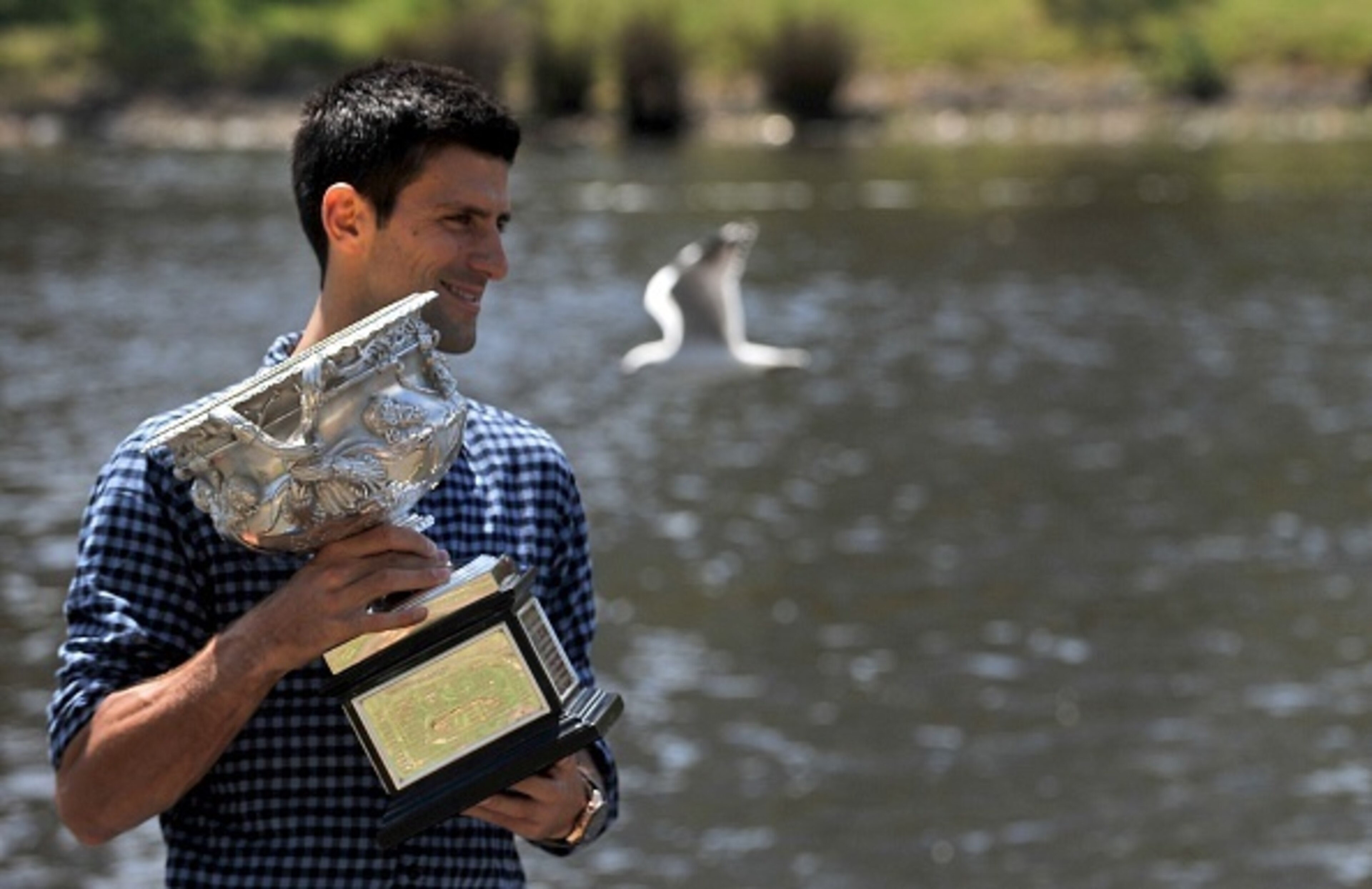 Novak Djokovic poses with the 2015 Australian Open trophy along the Yarra River in downtown Melbourne.