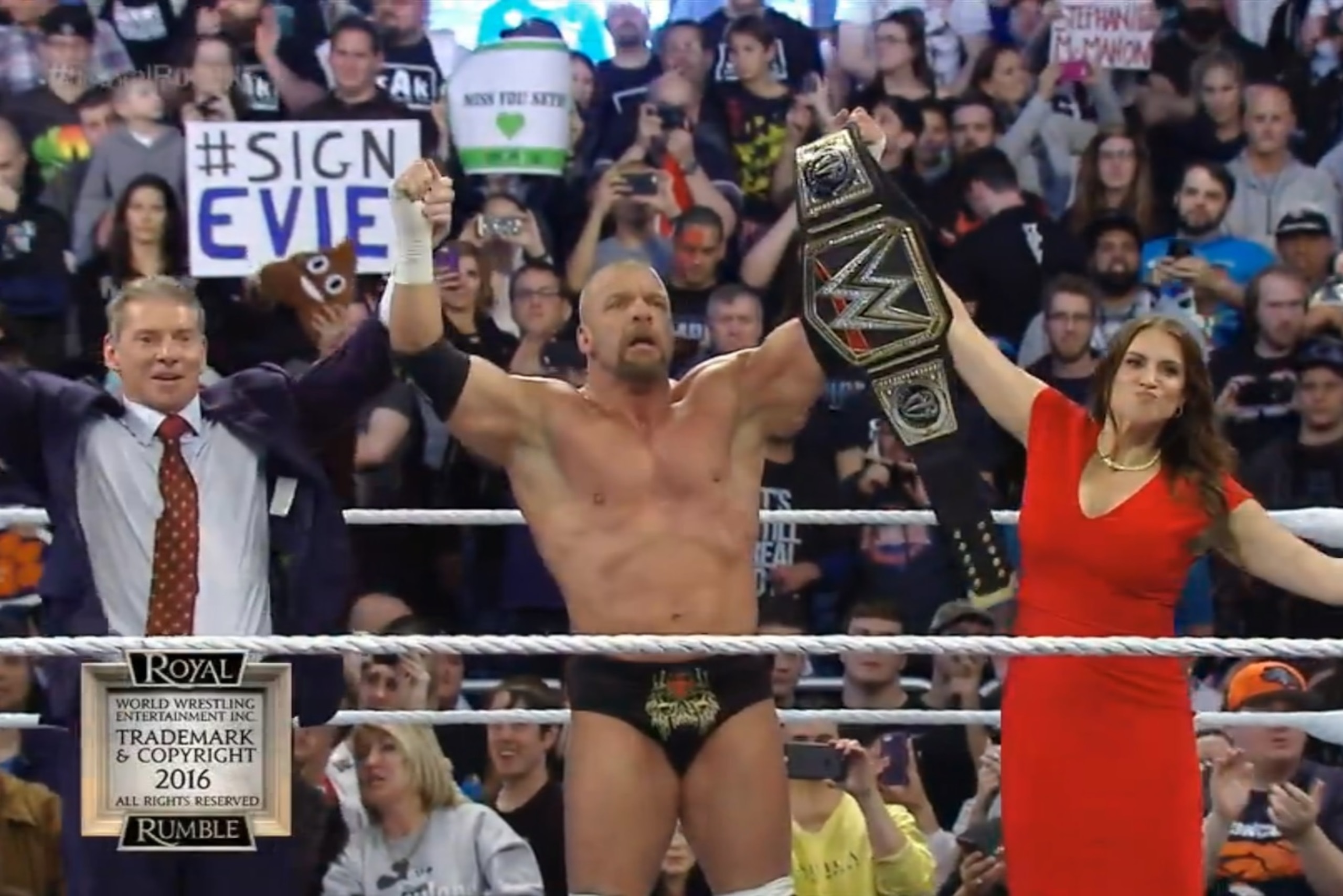 Triple H celebrates with Mr. McMahon and his wife Stephanie.