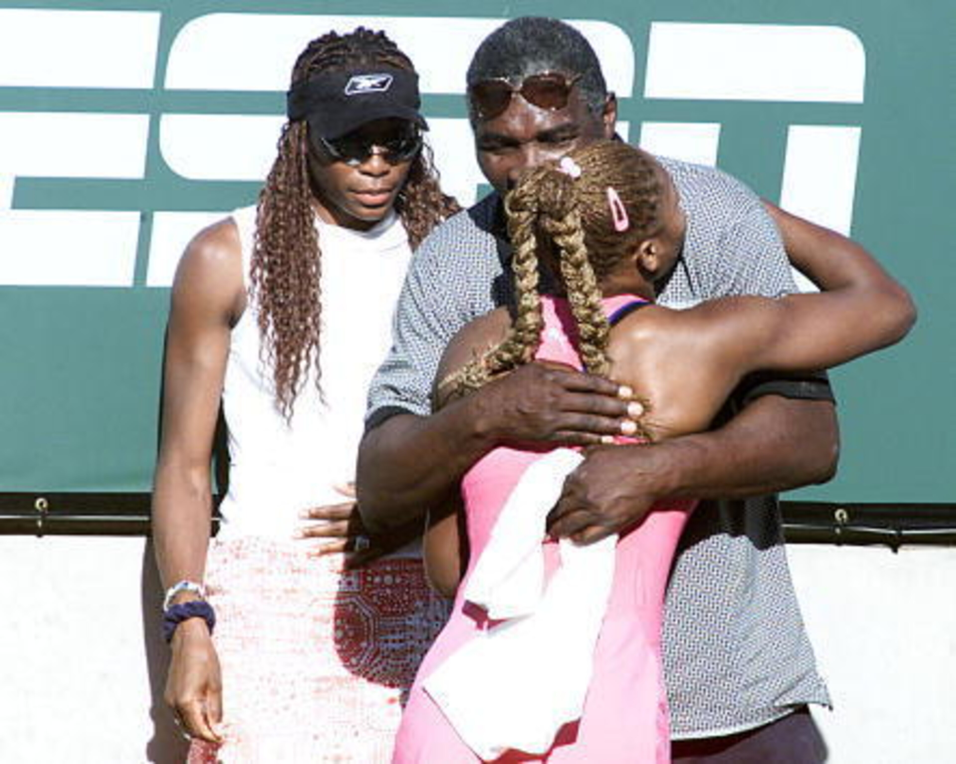 Venus Williams looks on as her father, Richard Williams, hugs Serena Williams after she won the 2001 Indian Wells title.