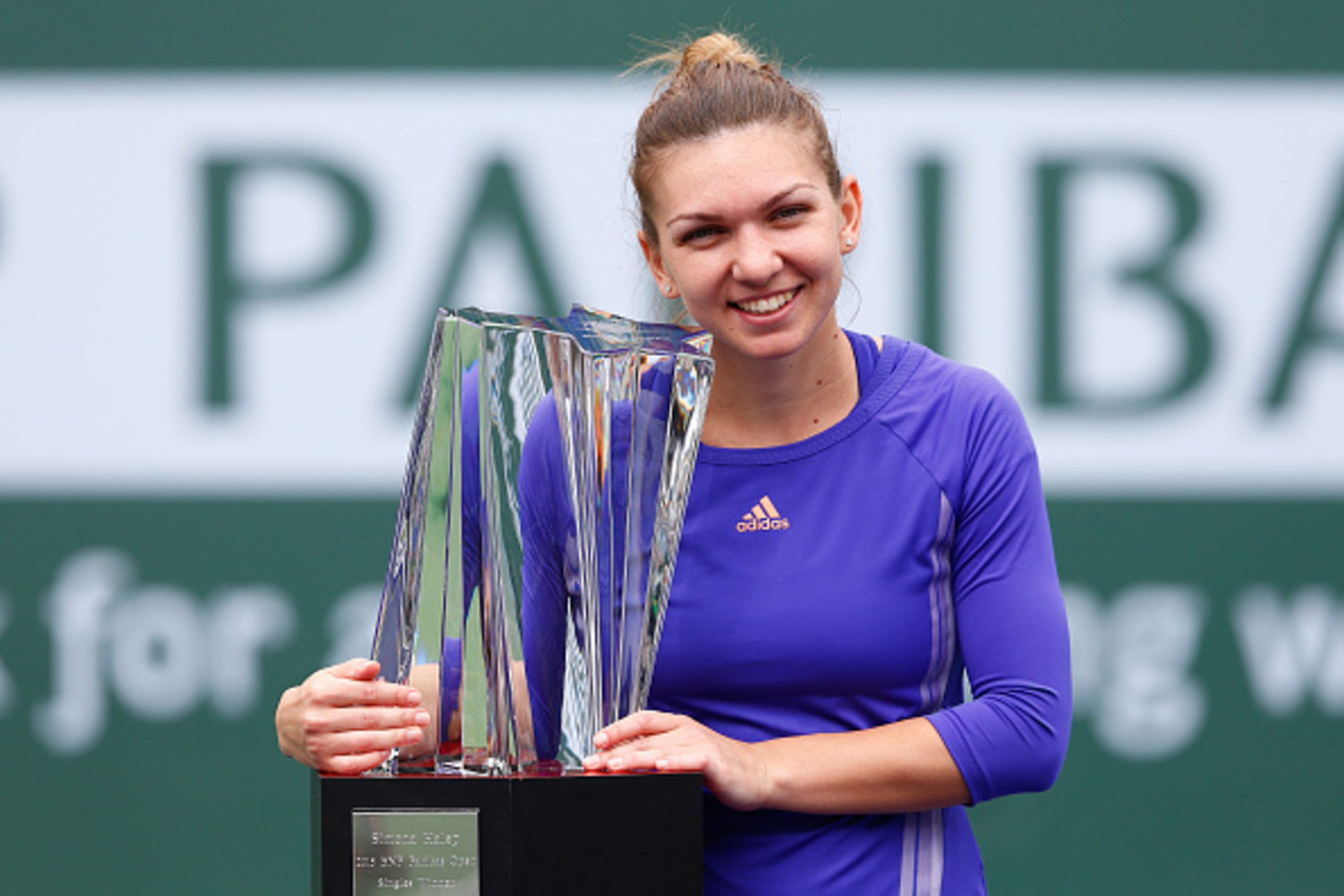 Halep holds the champion's trophy after winning last year's event.
