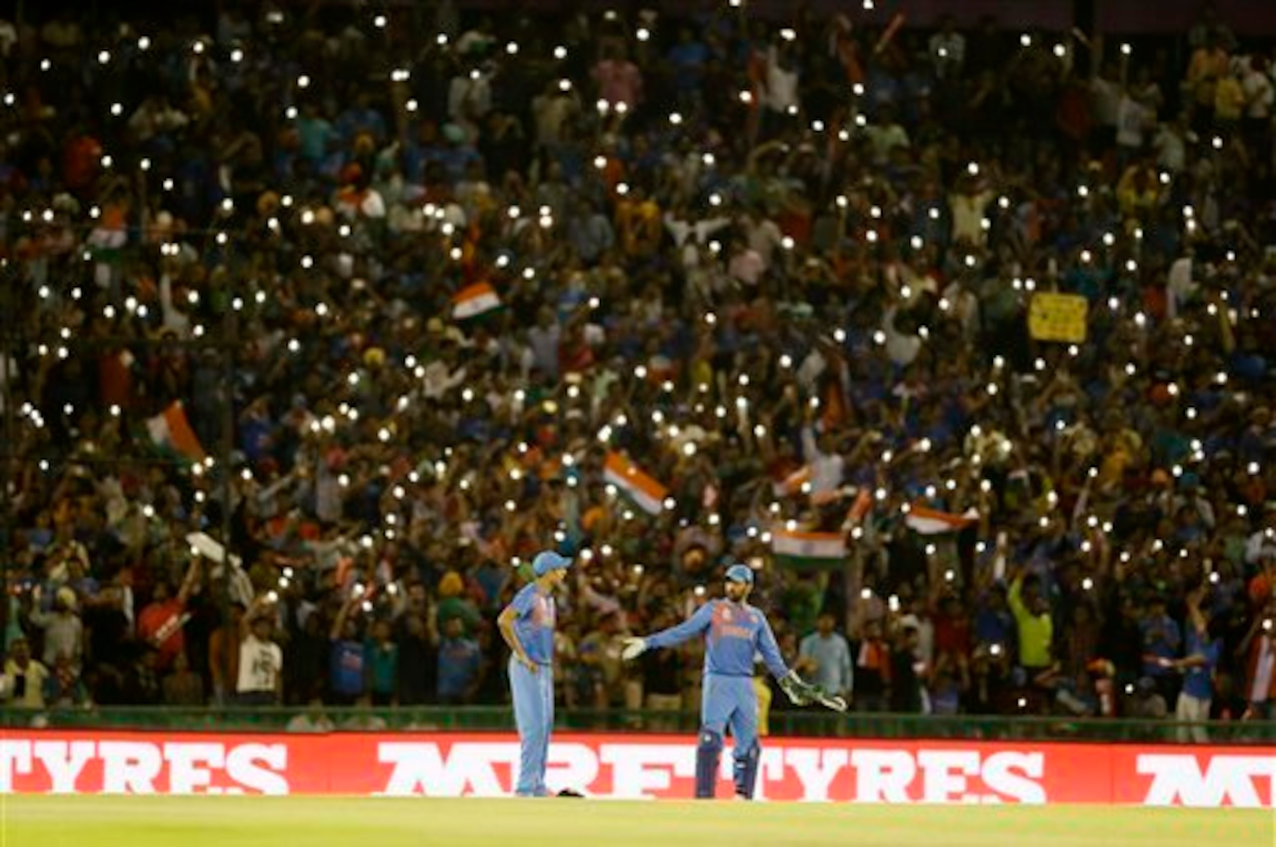 India's MS Dhoni, right, chats with teammate Ashish Nehra during their ICC World Twenty20 2016 cricket match against Australia in Mohali, India, Sunday, March 27, 2016. (AP Photo/Altaf Qadri)