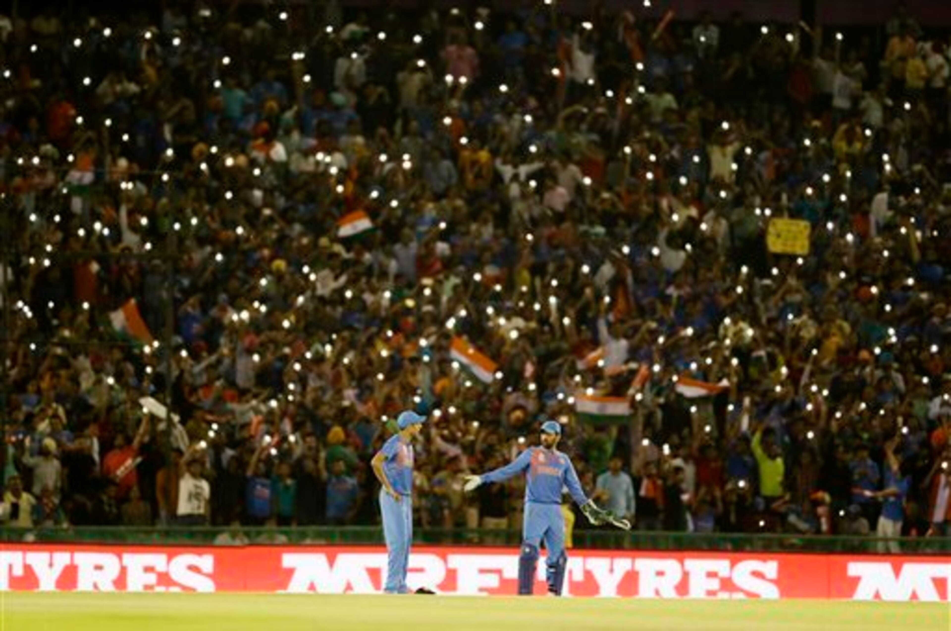 India's MS Dhoni, right, chats with teammate Ashish Nehra during their ICC World Twenty20 2016 cricket match against Australia in Mohali, India, Sunday, March 27, 2016. (AP Photo/Altaf Qadri)
