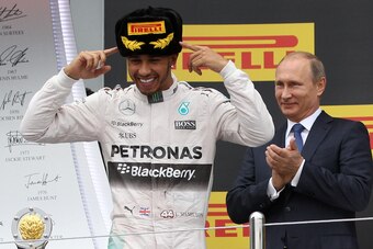 Lewis Hamilton celebrates his victory at the 2015 Russian Grand Prix while Vladimir Putin looks on.