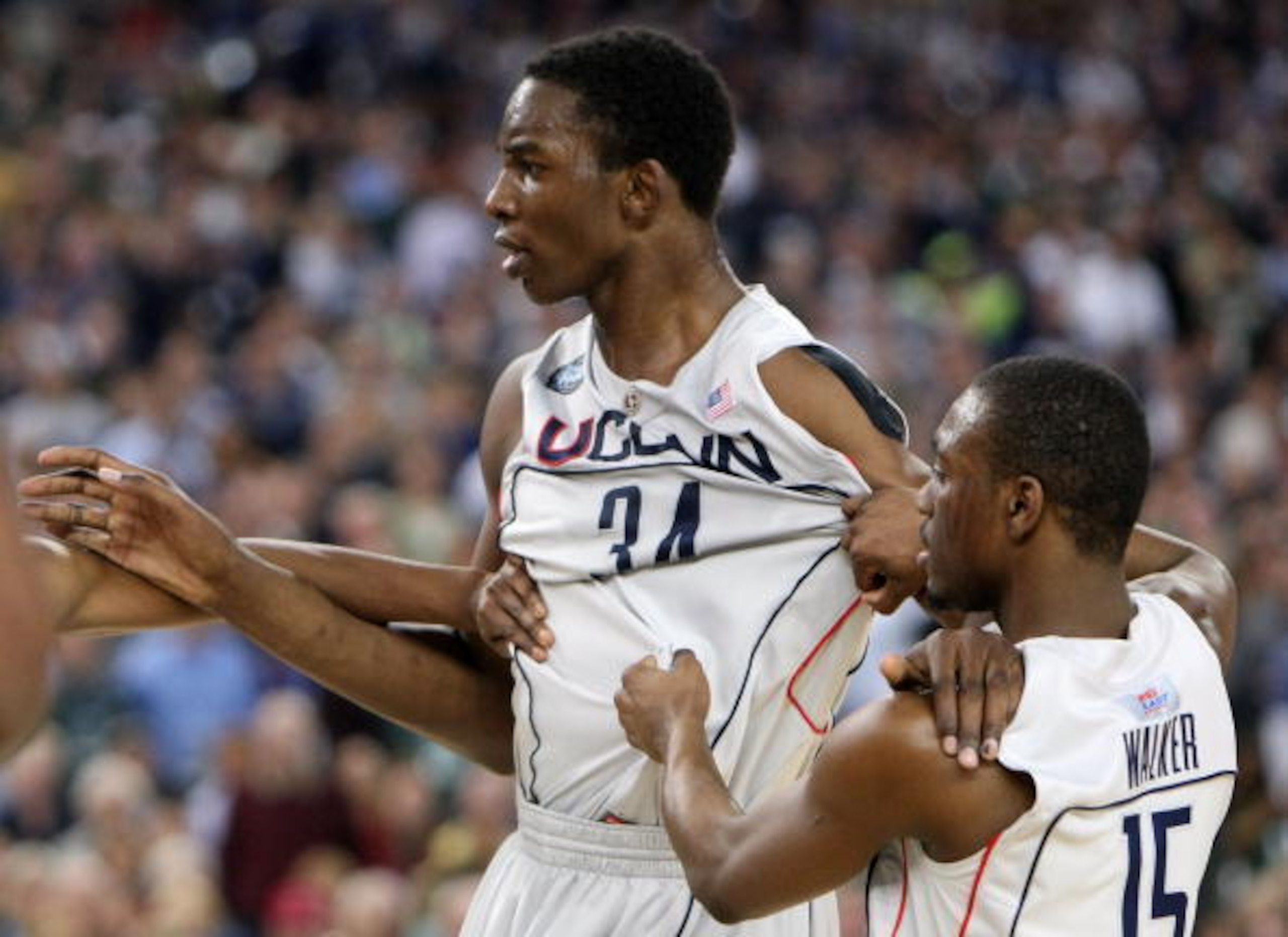 DETROIT - APRIL 04:  Hasheem Thabeet #34 of the Connecticut Huskies is restrained by teammate Kemba Walker #15 after Jeff Adrien #4 was fouled in the first half by Travis Walton #5 of the Michigan State Spartans during the National Semifinal game of the N