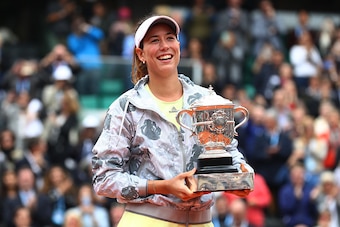 Garbine Muguruza smiles with the trophy after winning the 2016 French Open.