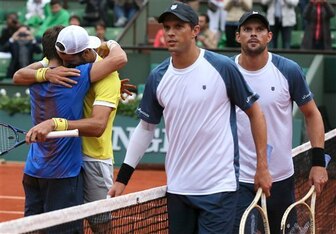 Marc Lopez and Feliciano Lopez celebrate winning the doubles title as Mike and Bob Bryan exit the court at the 2016 French Open.