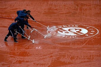 Grounds crew sweep rain off tarp at Roland Garros.