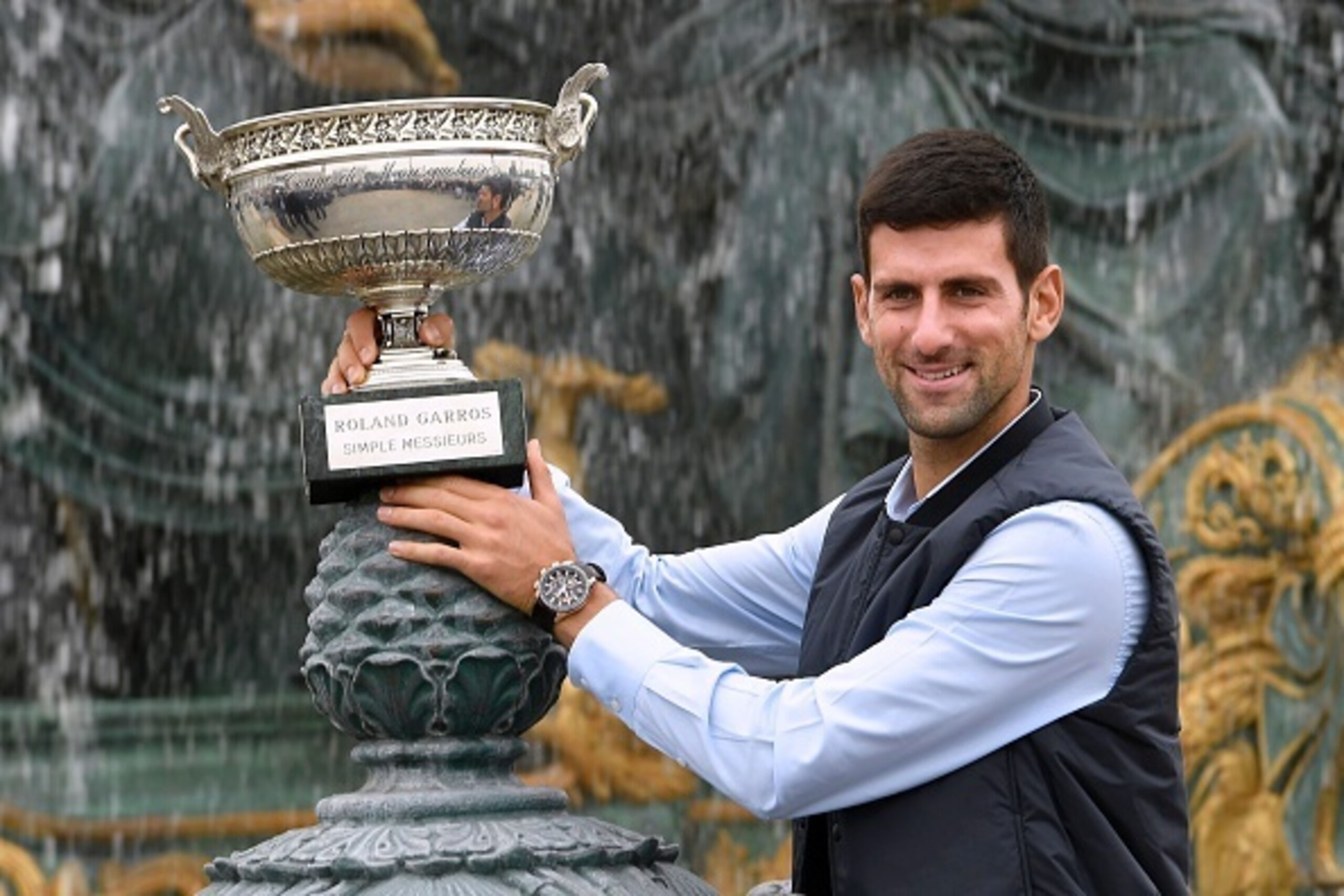 Novak Djokovic shows off his new trophy after winning the 2016 French Open.