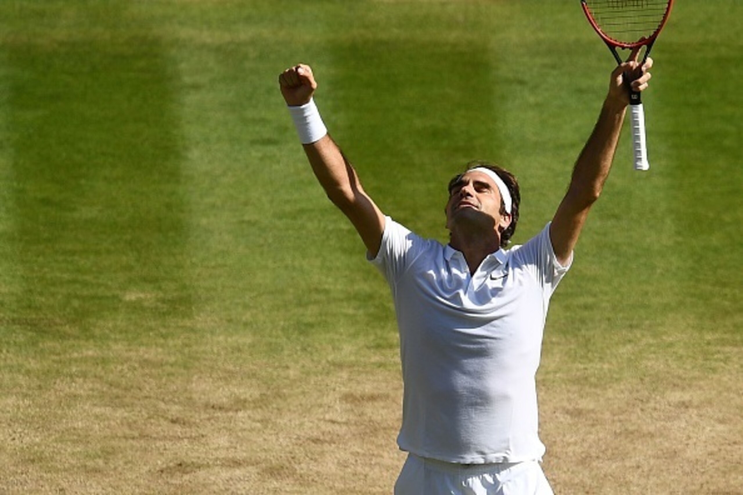 Federer raises his arms in relief after squeaking by Cilic in the quarterfinals.