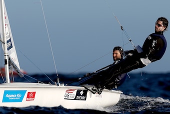 Stuart McNay has the 470 helm, while David Hughes dangles over the water.
