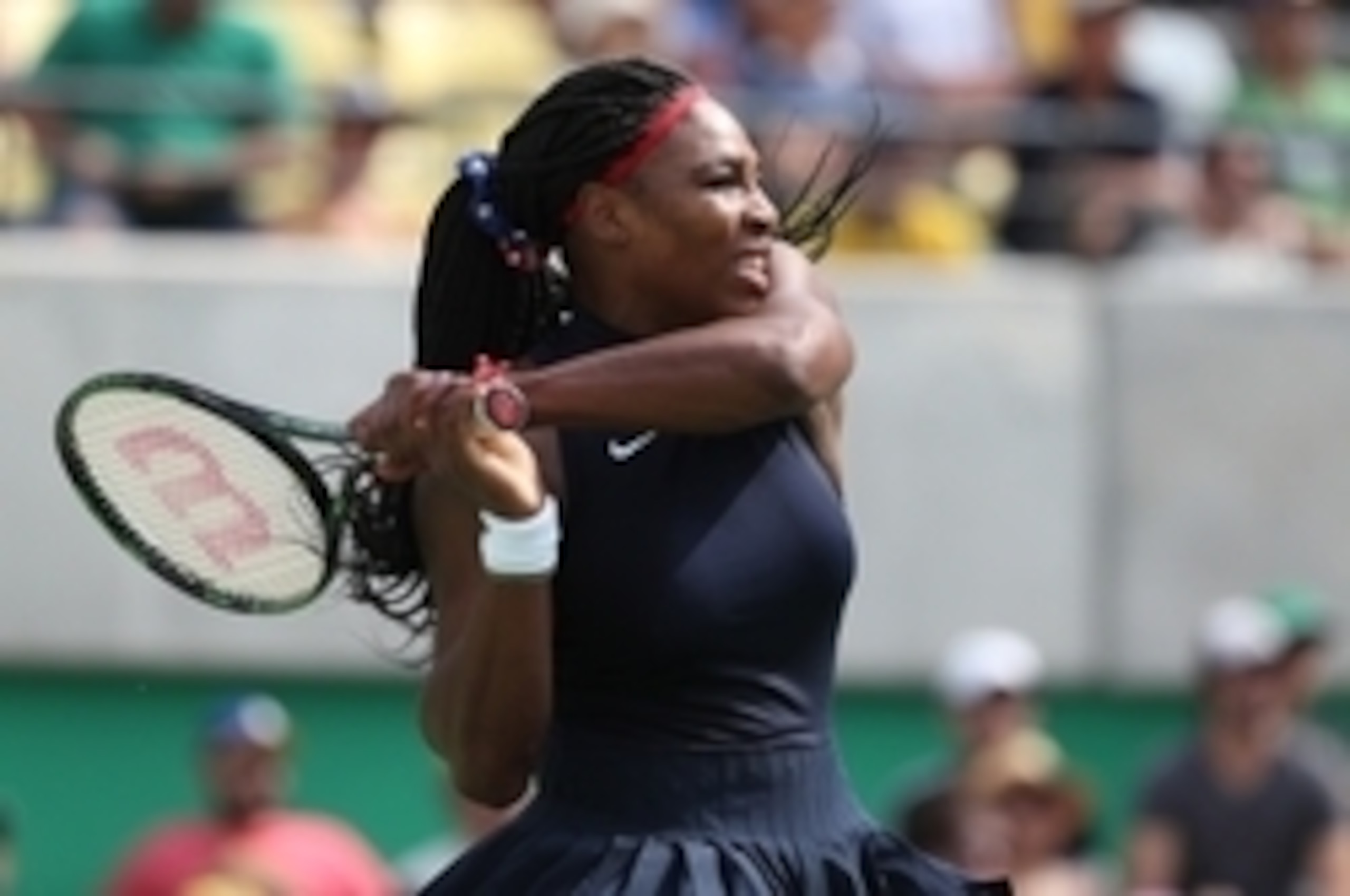 Serena Williams hits a backhand during her first-round match at the 2016 Olympics.